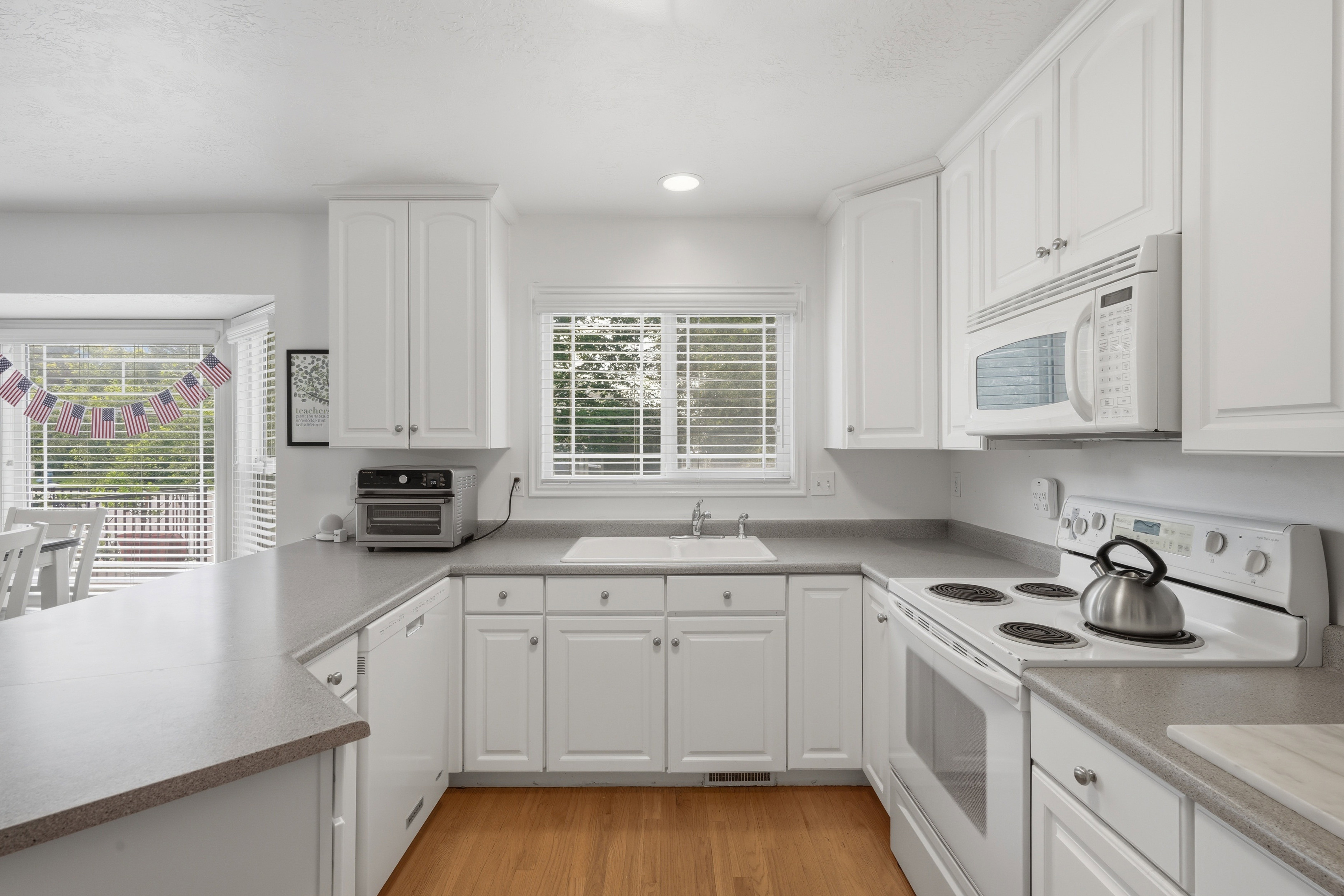 Bright kitchen featuring white cabinetry and light countertops