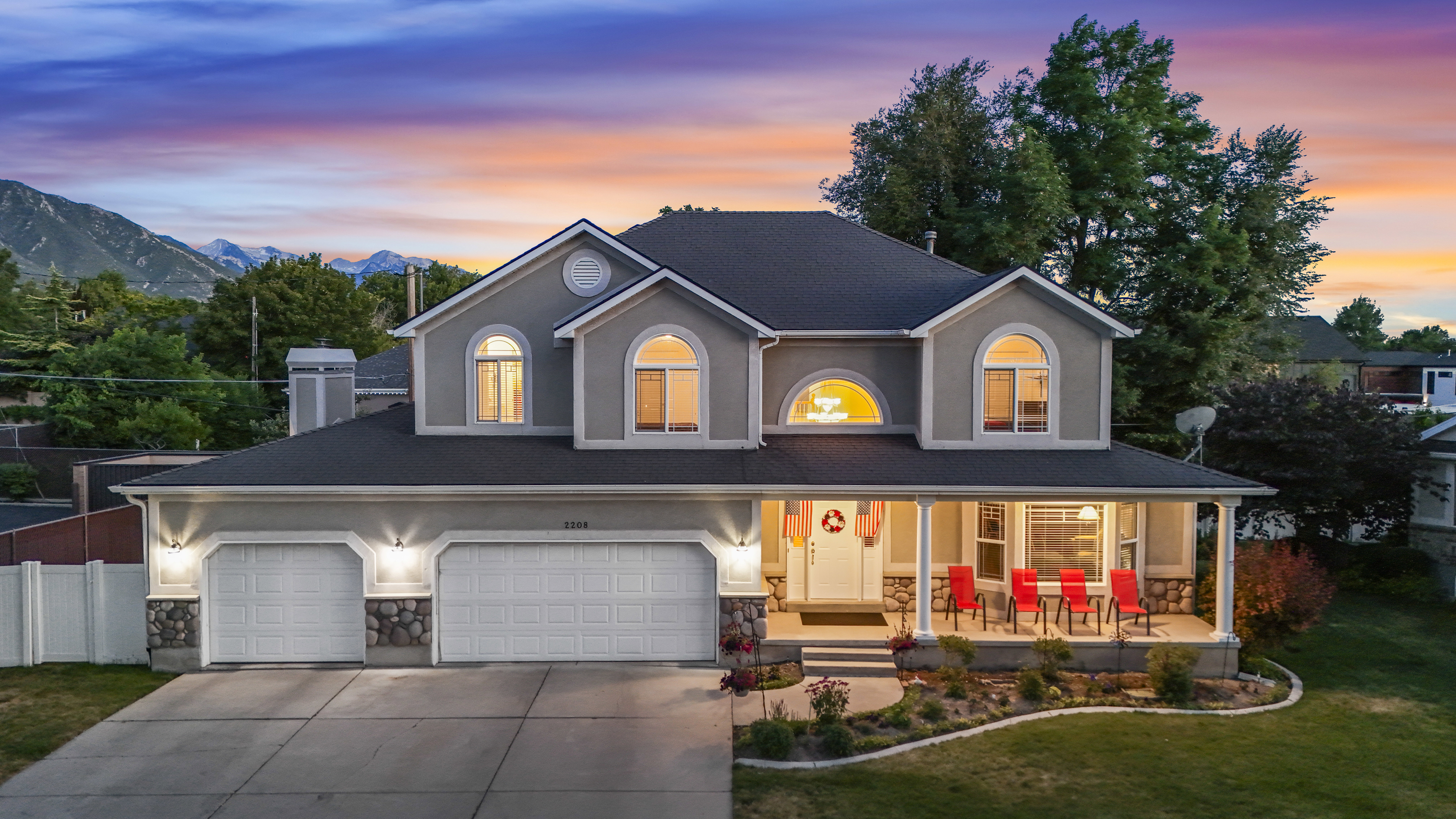 Stucco exterior with stone accents and a covered front porch featuring white pillars