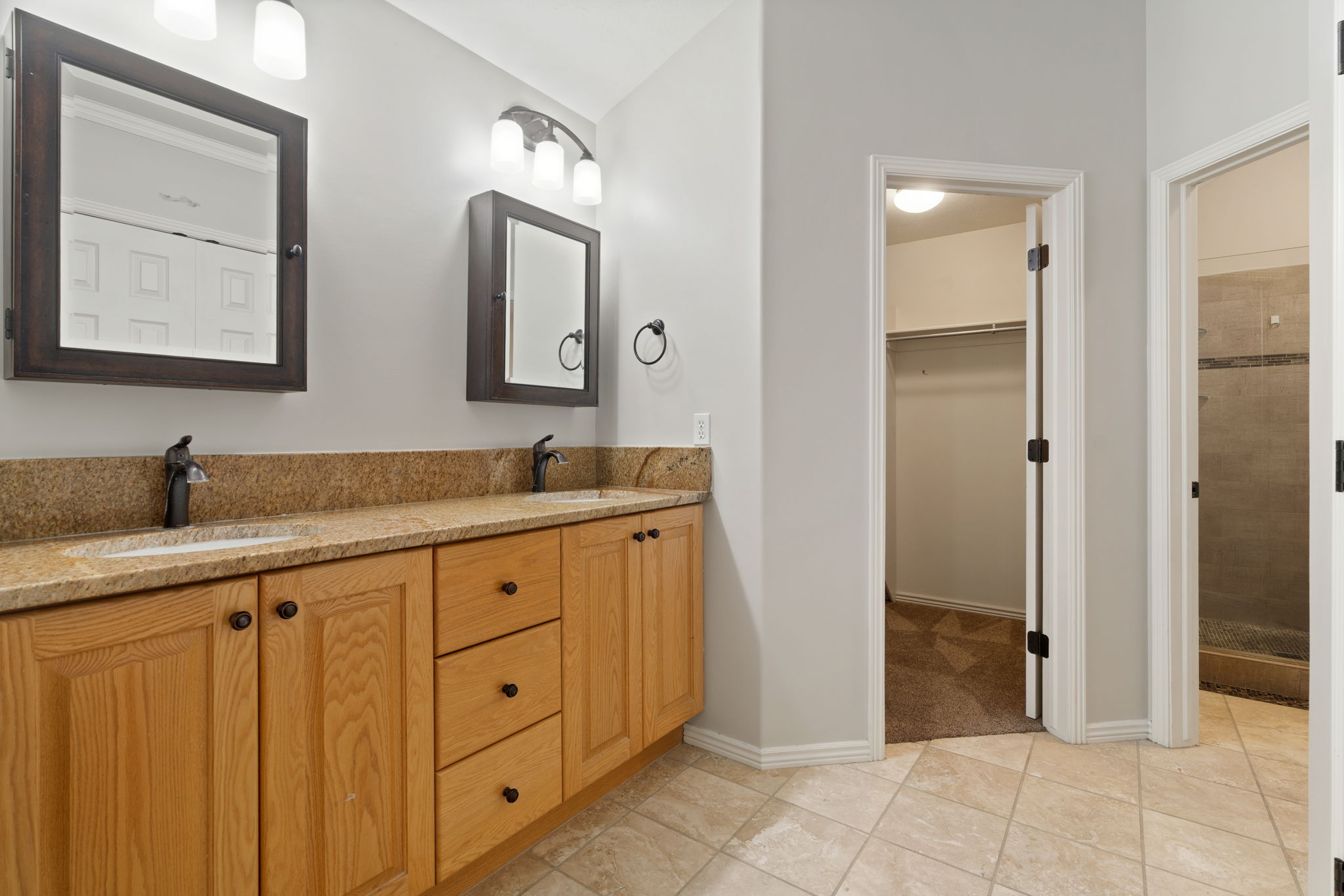 Owner's ensuite featuring dual vanity with light wood cabinetry