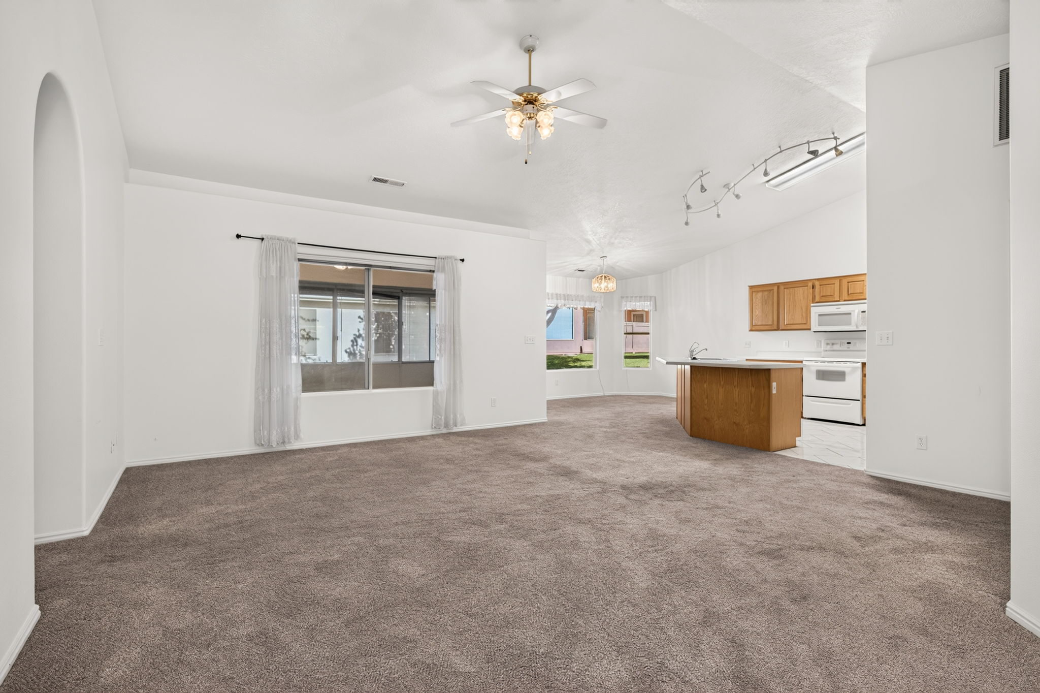 Open concept living area with vaulted ceilings and recessed lighting
