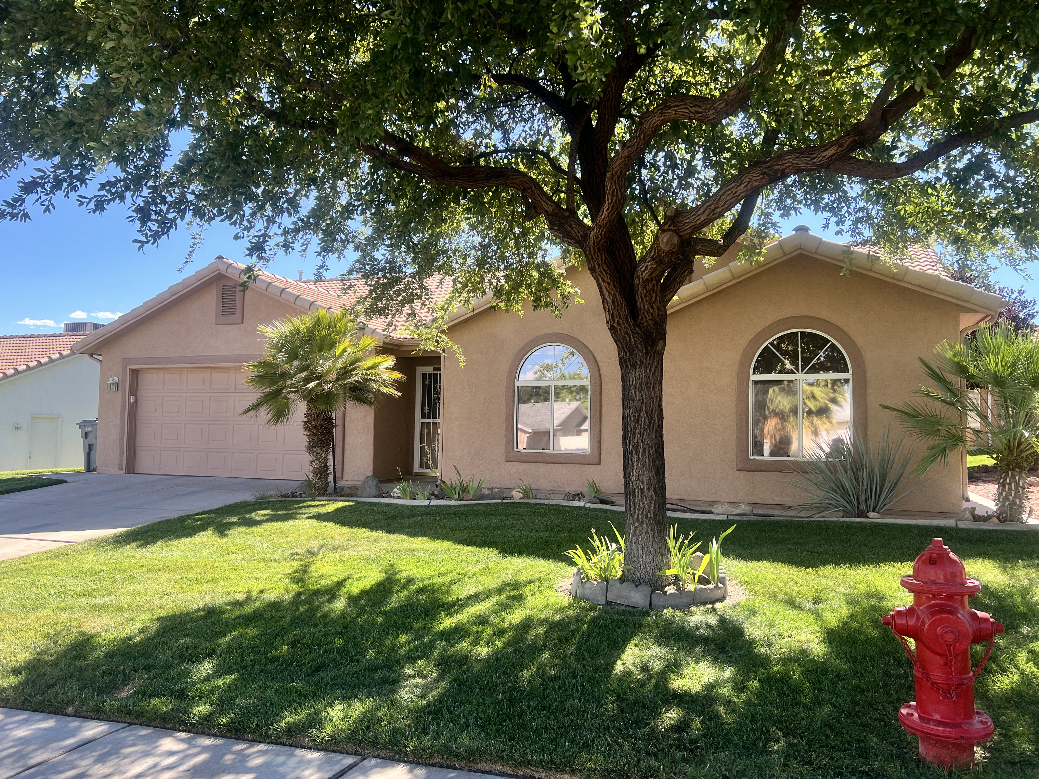 Stucco exterior residence with a front-facing attached garage and arched windows
