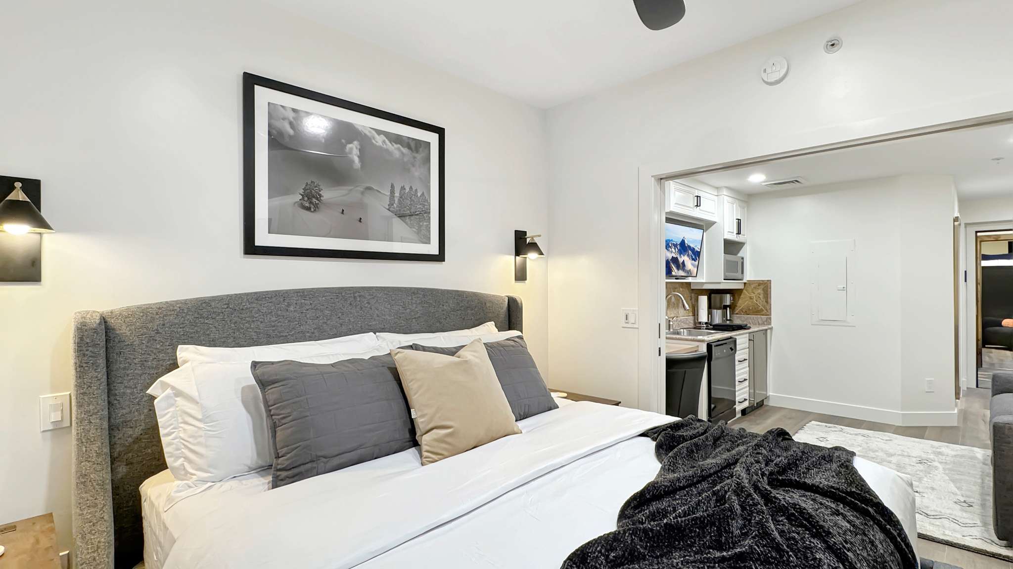 Integrated bedroom space featuring a built-in kitchenette with a sink and microwave