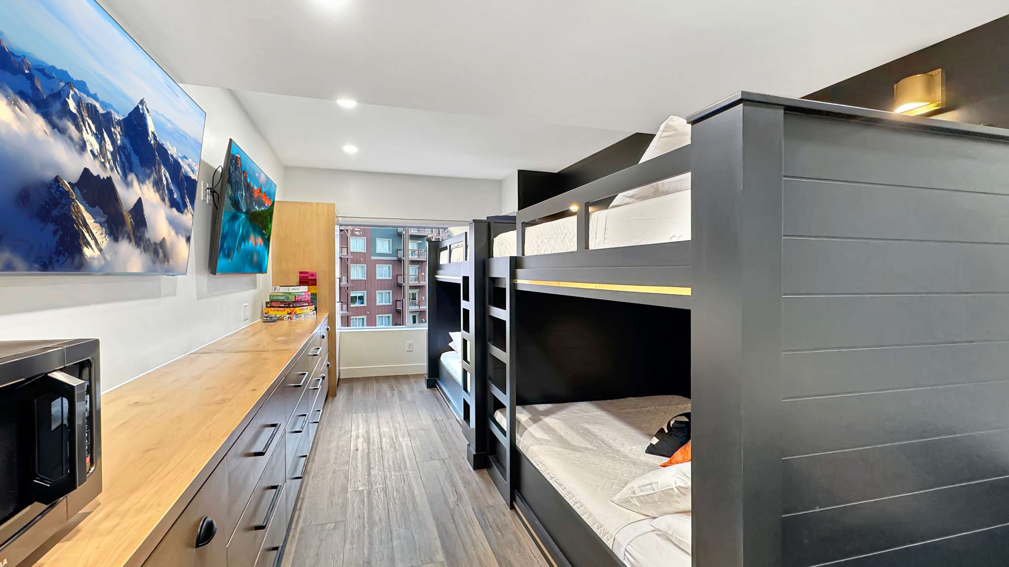 Room featuring wood-finish flooring, recessed lighting, and wall-mounted televisions