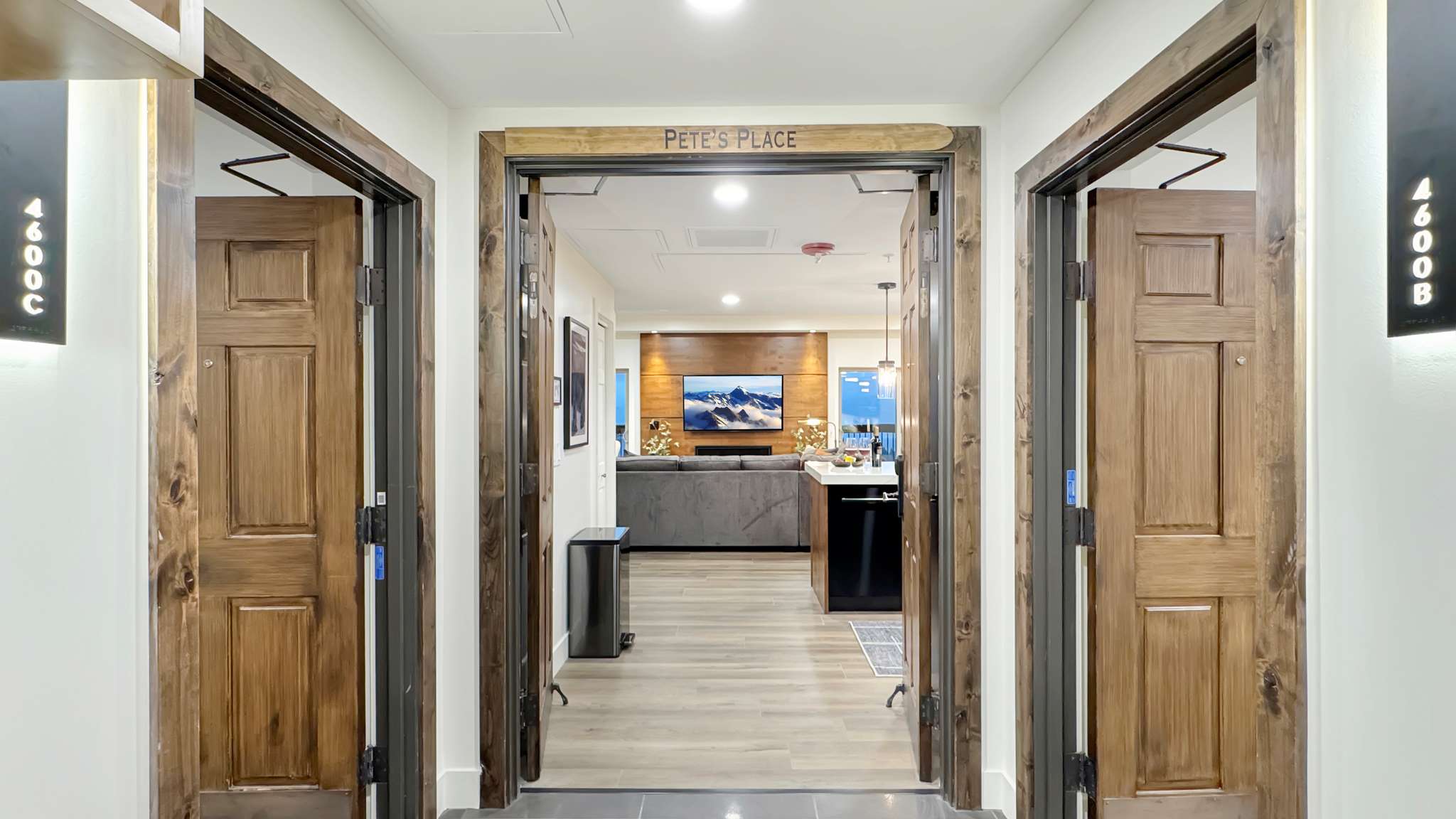 Entryway featuring three wood-paneled doors with dark wood trim