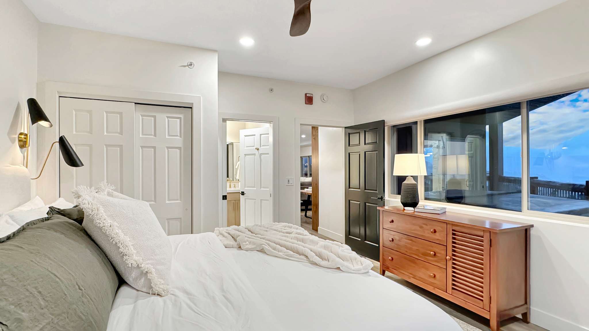Spacious room with large windows, recessed lighting, and a ceiling fan