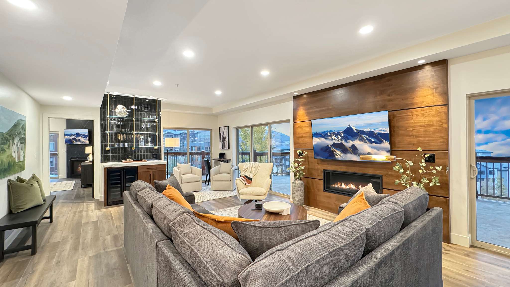 Spacious living area featuring a modern linear fireplace set within a wood-paneled feature wall