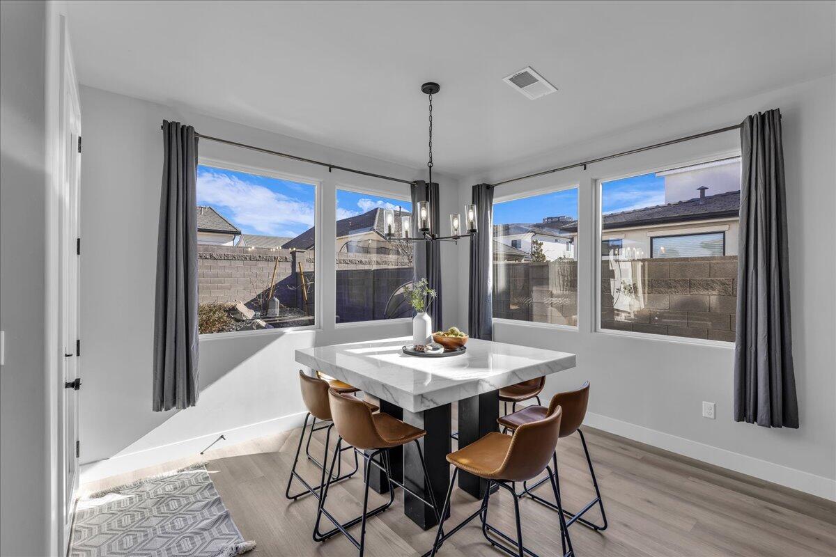 Corner dining area featuring wood-finish flooring and a contemporary chandelier