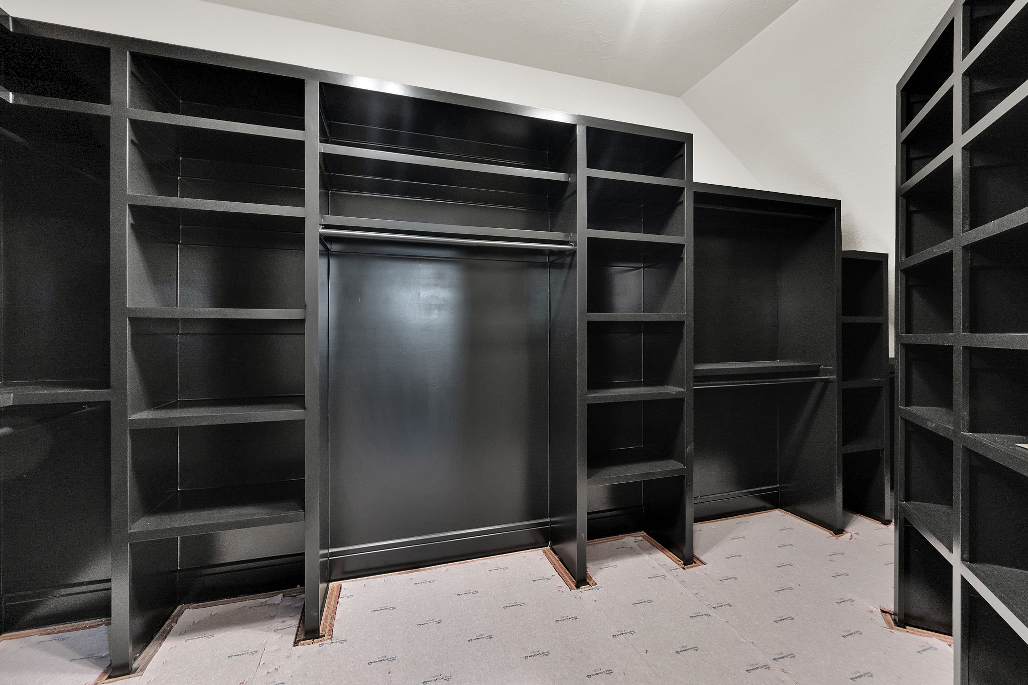 Custom closet system featuring dark-finish shelving and integrated hanging rods