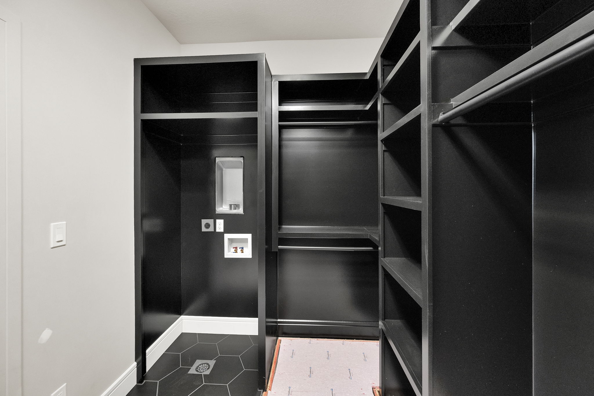 Custom closet system featuring dark cabinetry and extensive shelving