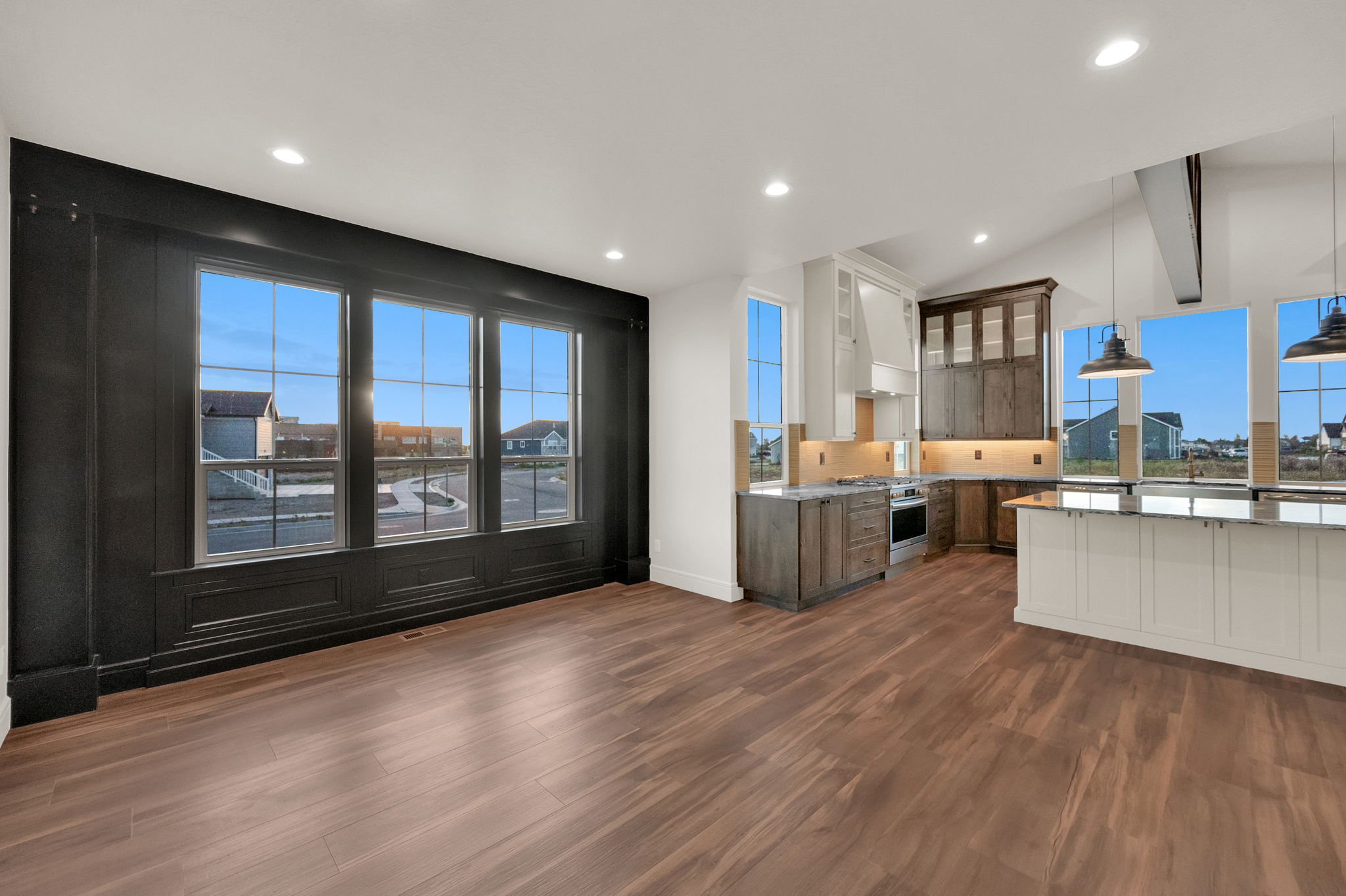 Open-concept living space featuring wood-finish flooring, recessed lighting, and a kitchen with an island