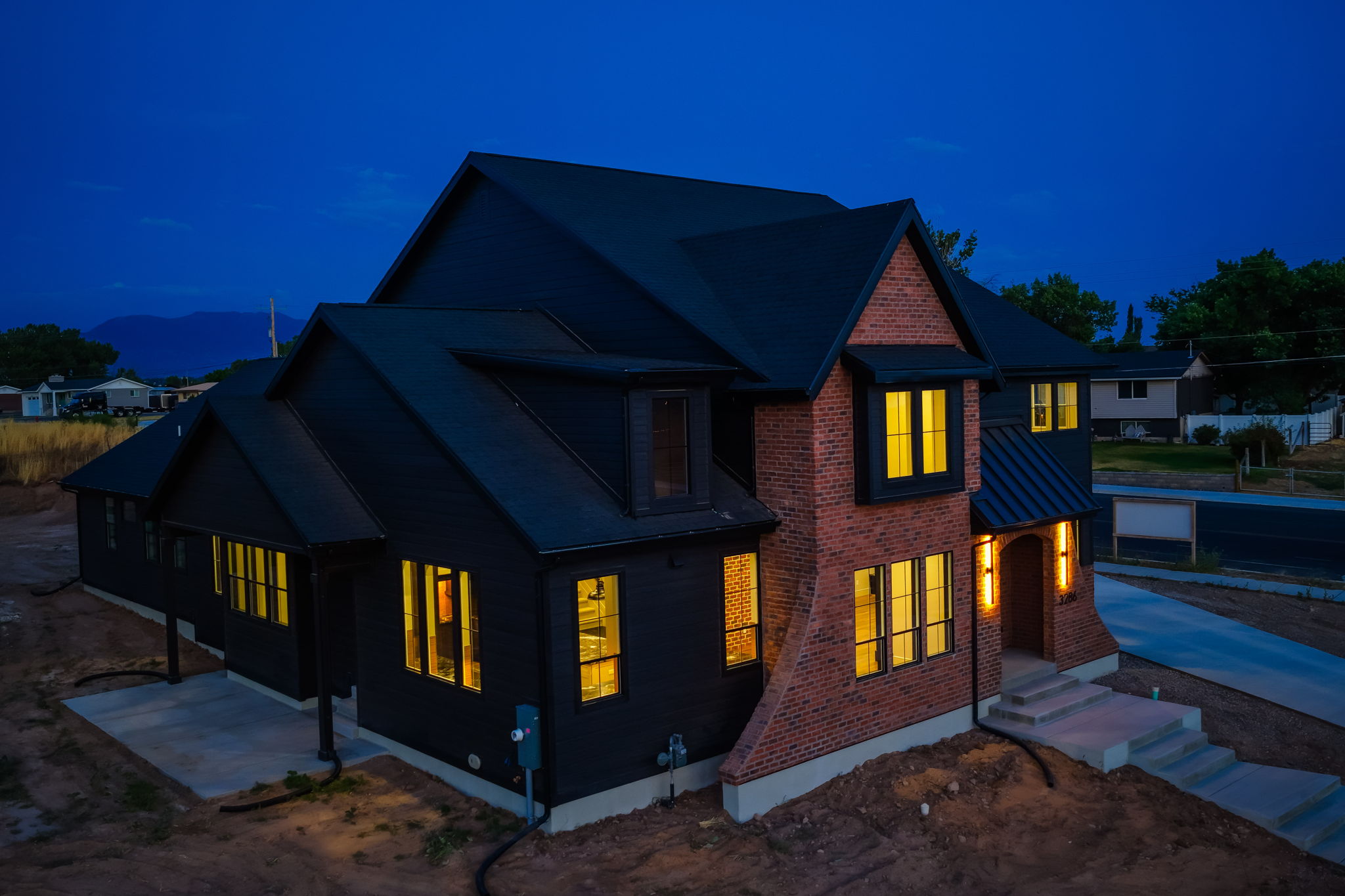 Modern residence featuring a dark siding facade and red brick accents
