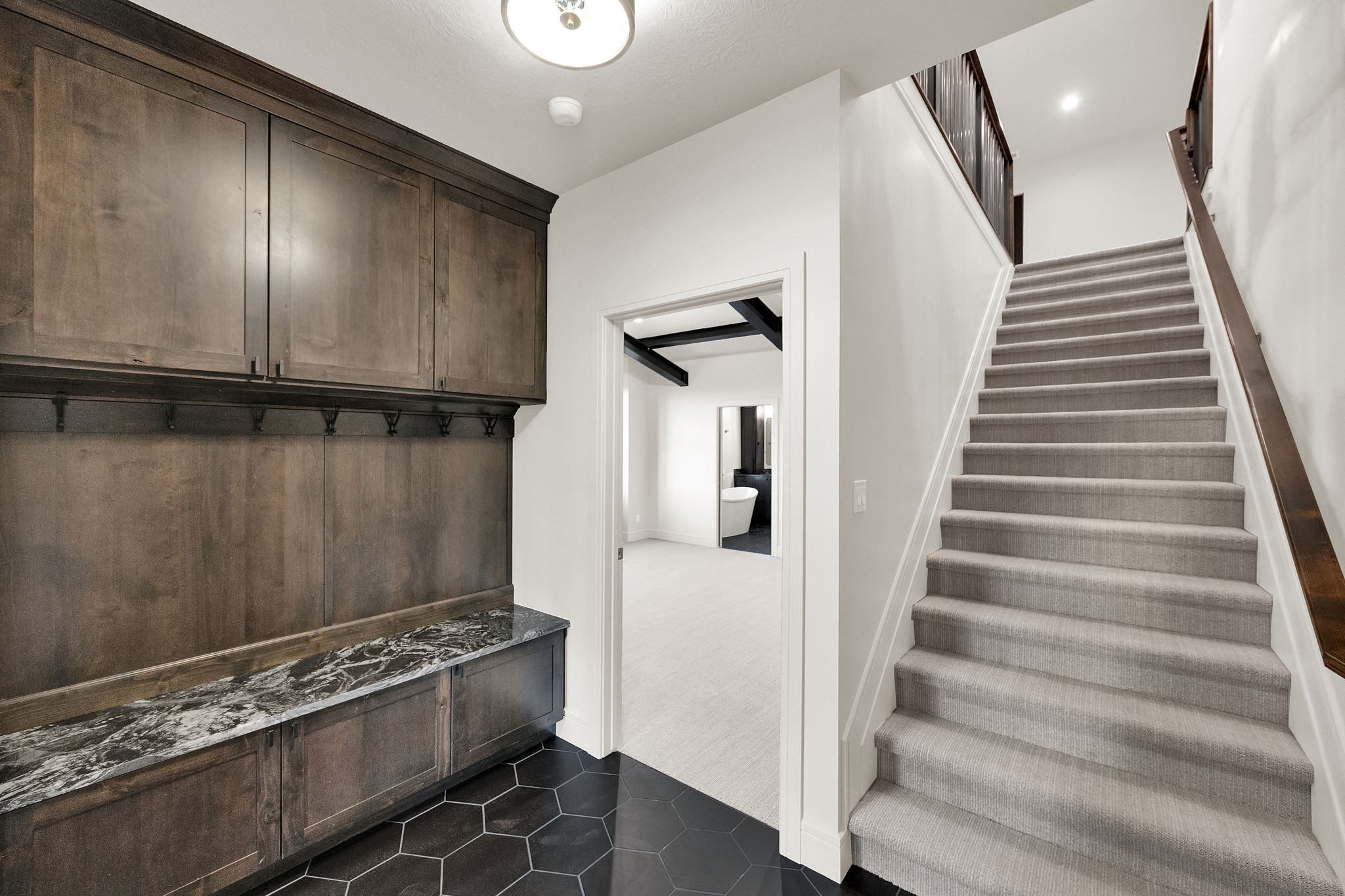 Built-in wood cabinetry with storage hooks and a stone countertop