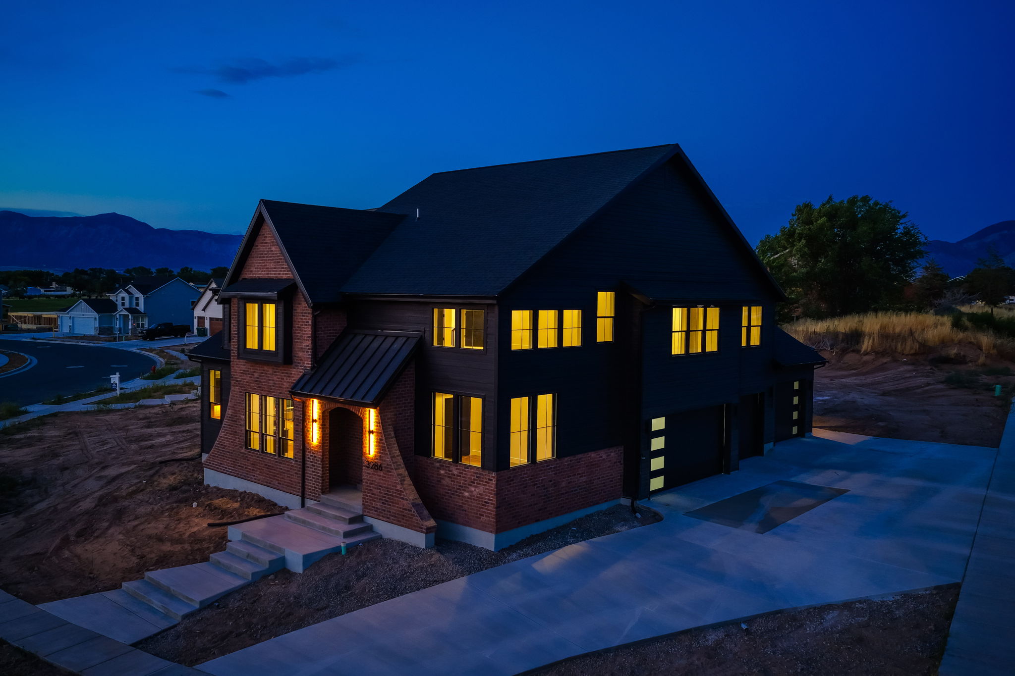 Modern two-story residence featuring a dark siding and brick exterior
