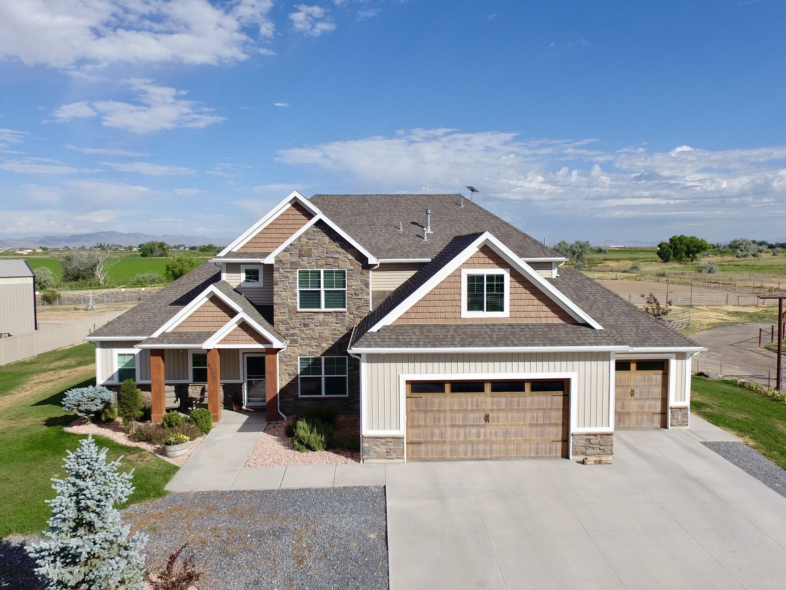Modern craftsman-style residence featuring a stone and siding exterior