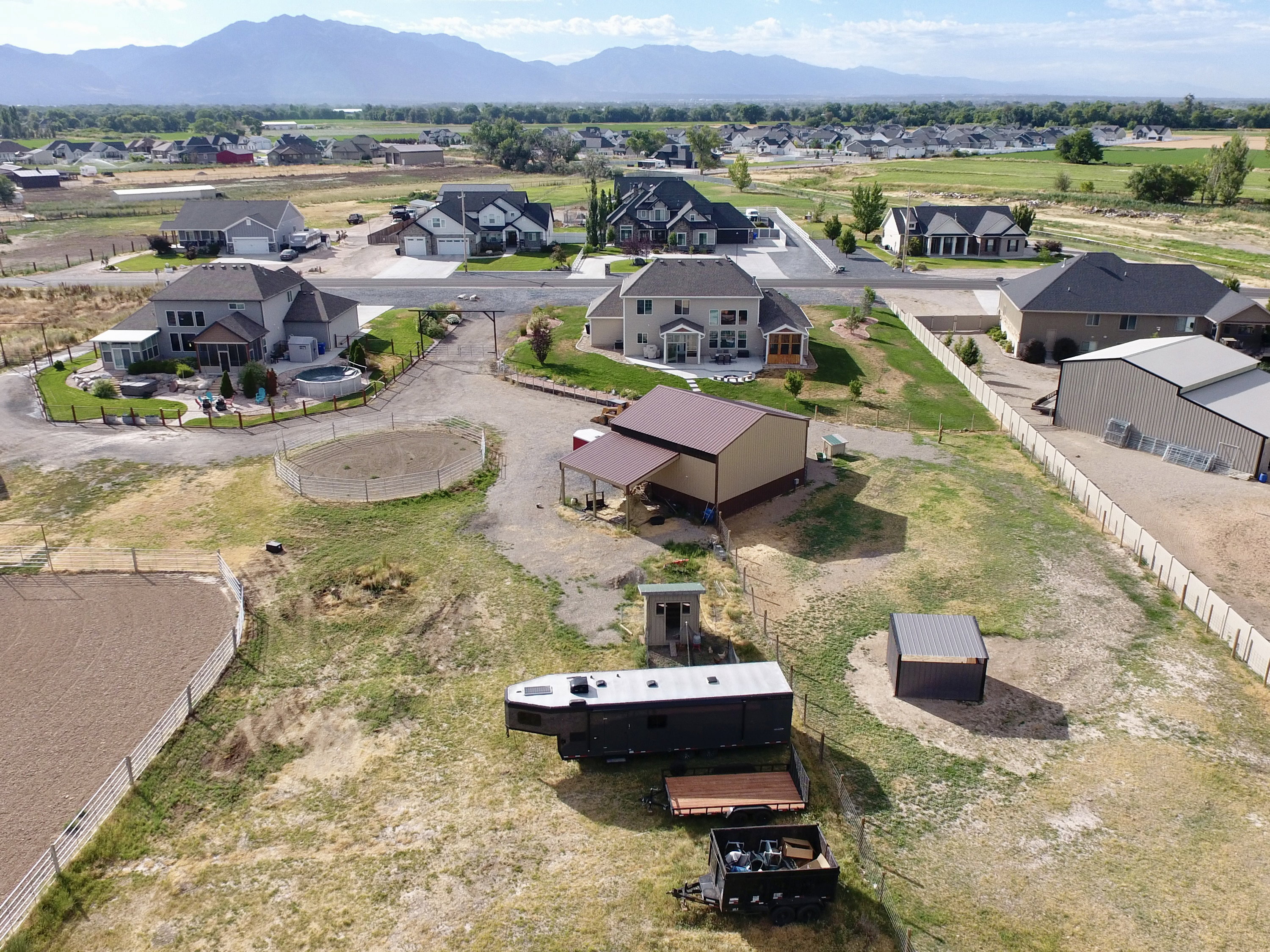 Expansive property featuring a gravel driveway, multiple outbuildings, and fenced areas