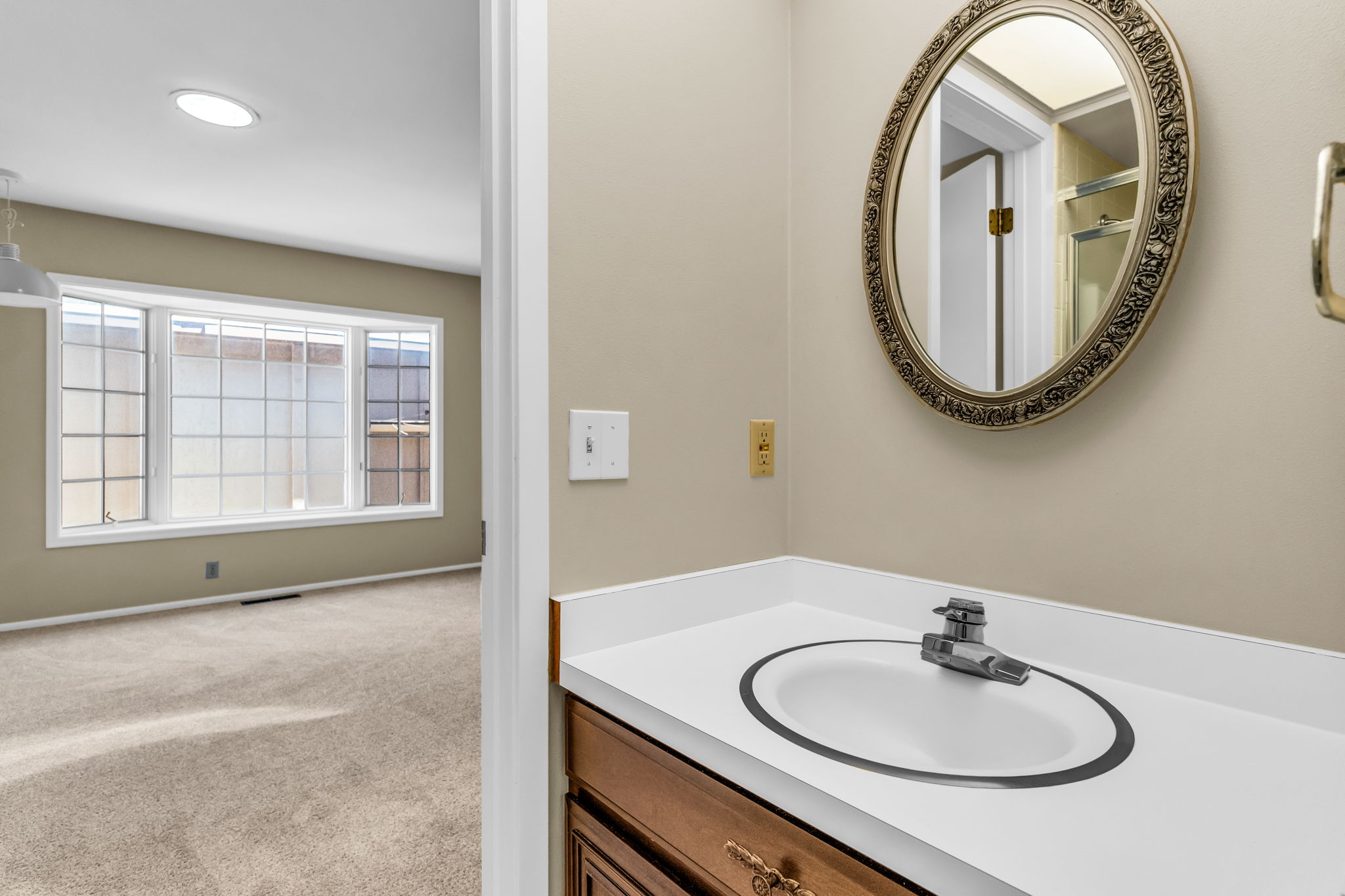 Vanity with integrated sink and chrome faucet, set against warm-toned walls