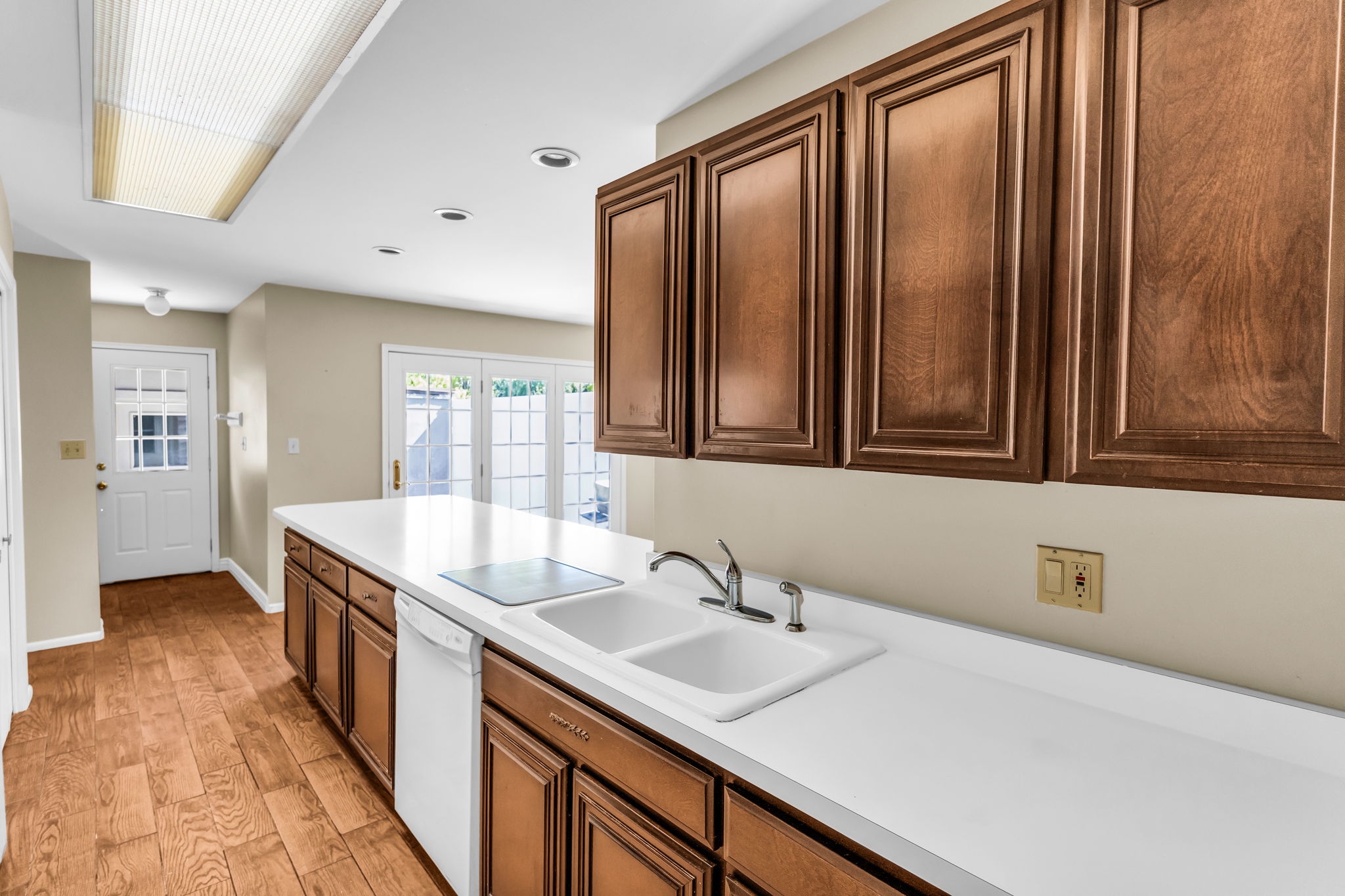 Kitchen featuring extensive counter space, wood-finish flooring, and built-in cabinetry