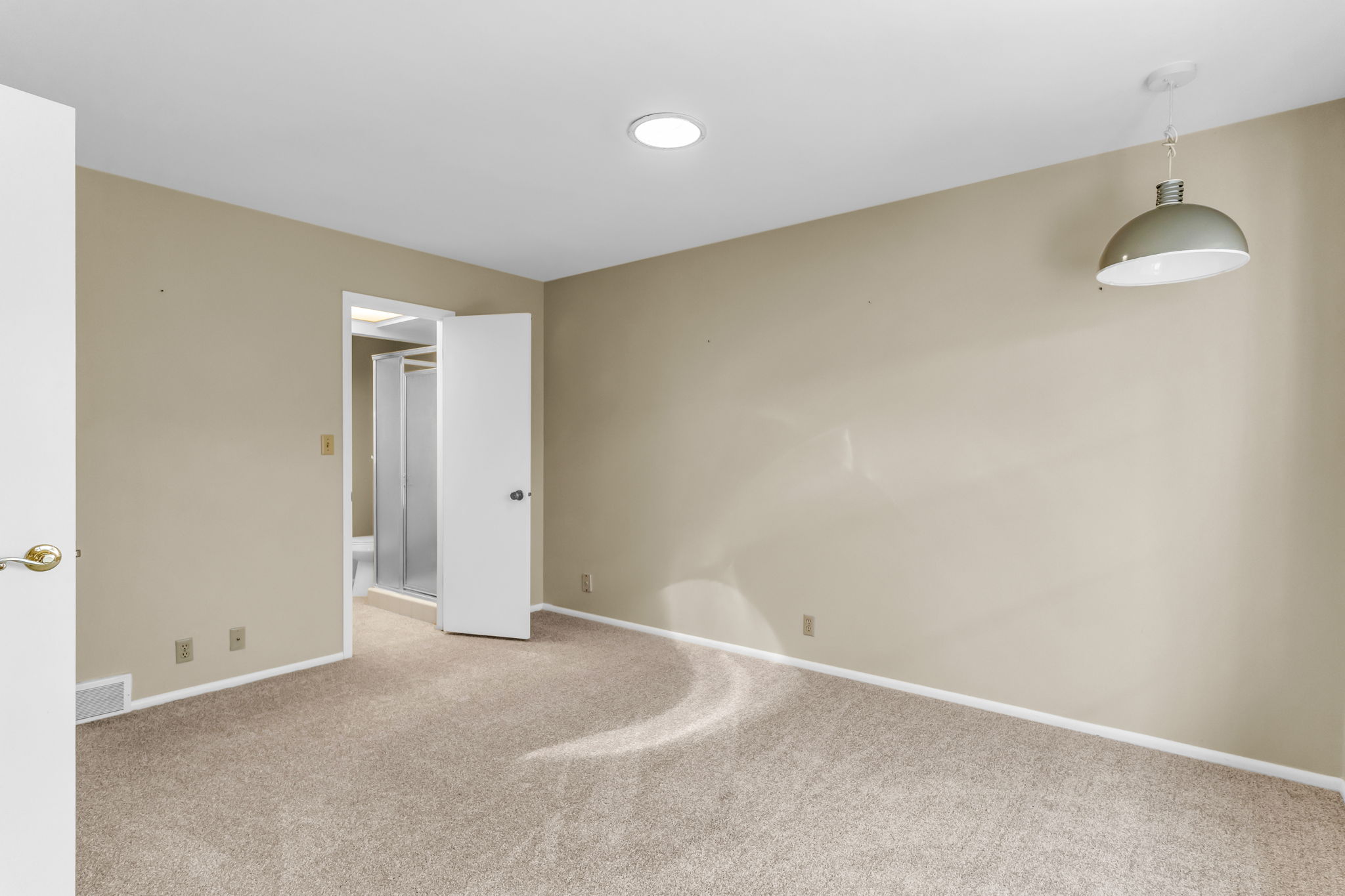 Carpeted room featuring a ceiling-mounted light fixture, recessed lighting, and direct access to an enclosed shower