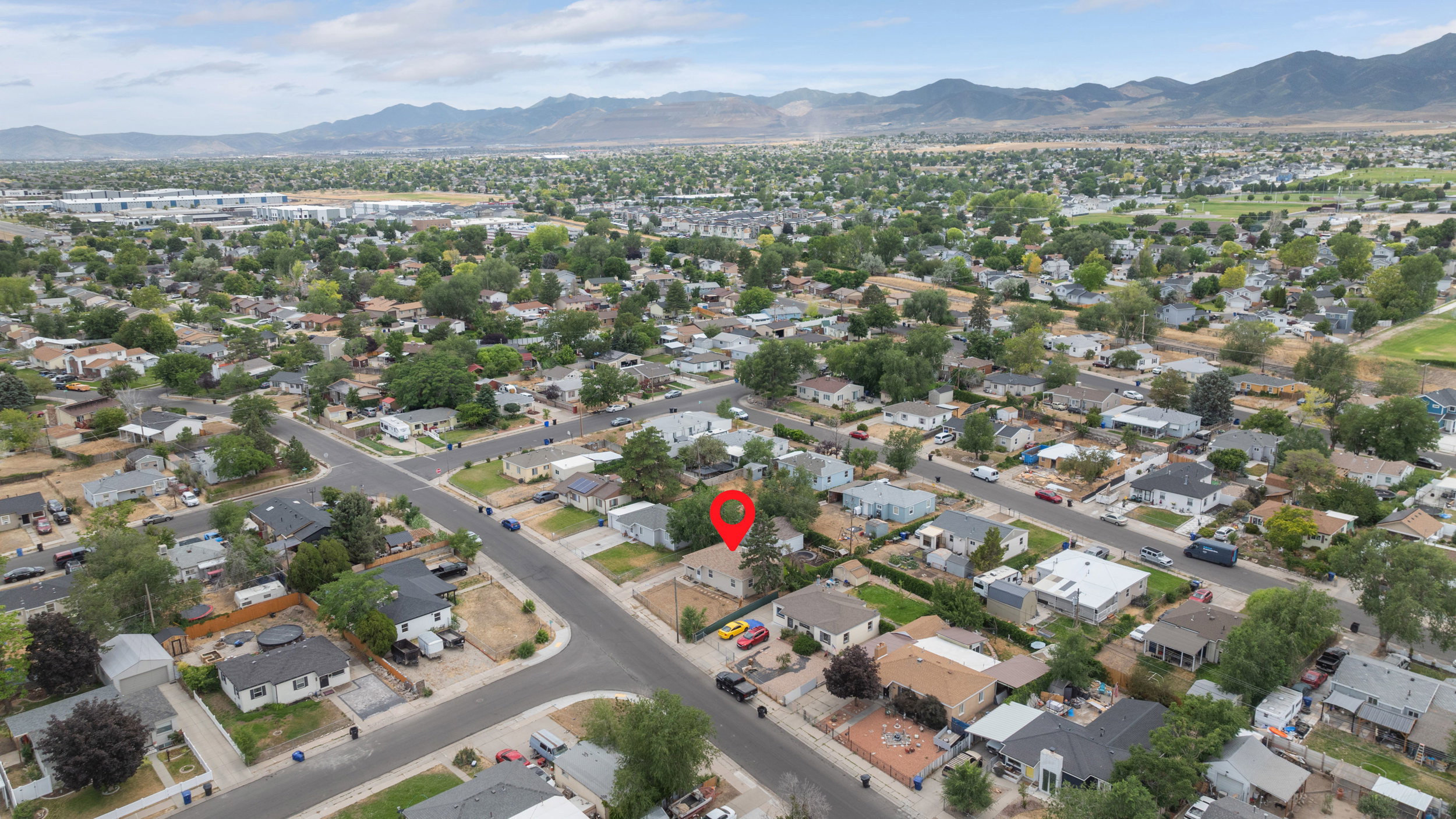 Aerial perspective showcasing a residential neighborhood with a distant mountain range backdrop