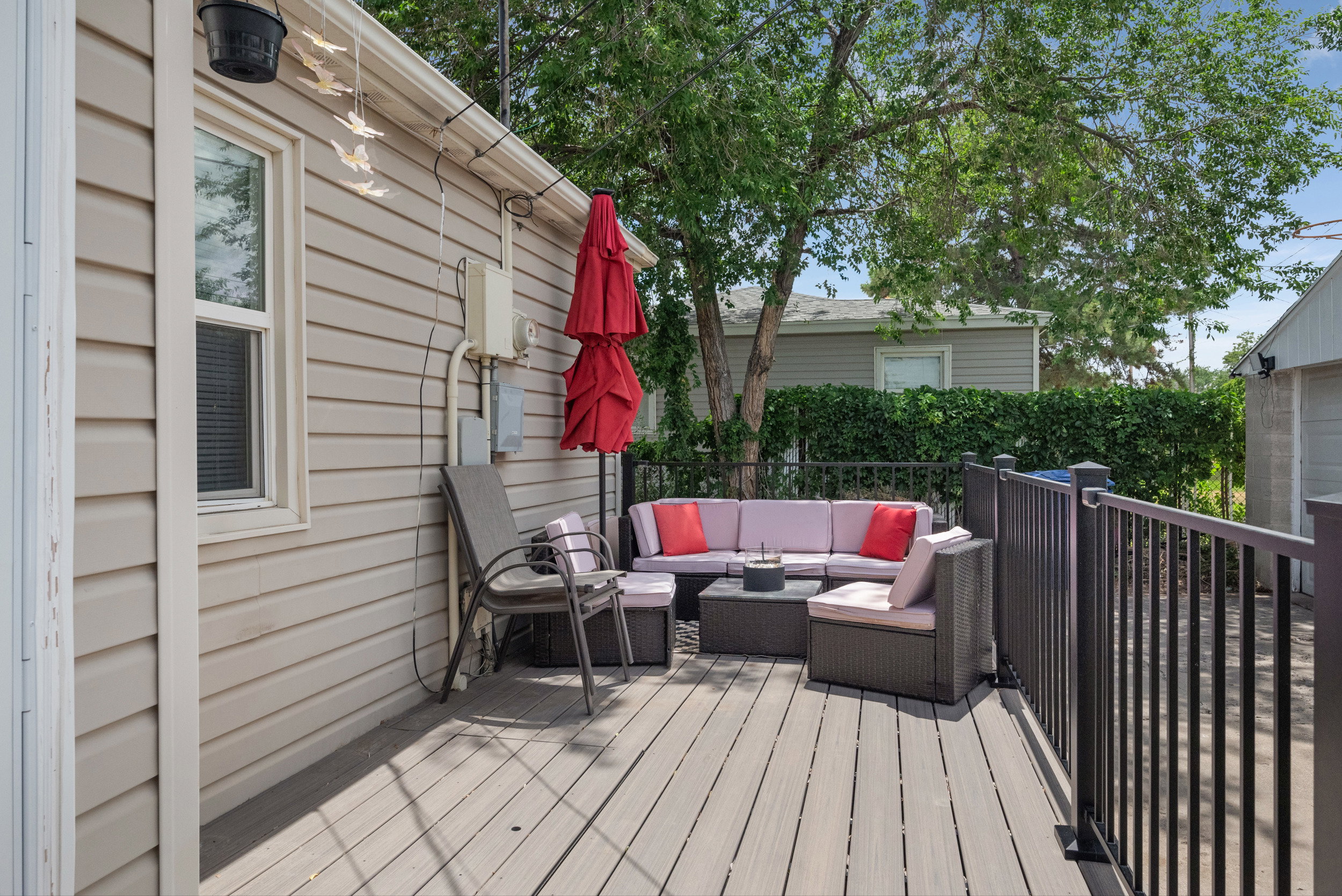 Expansive exterior deck featuring composite decking, black metal railings, and tan siding