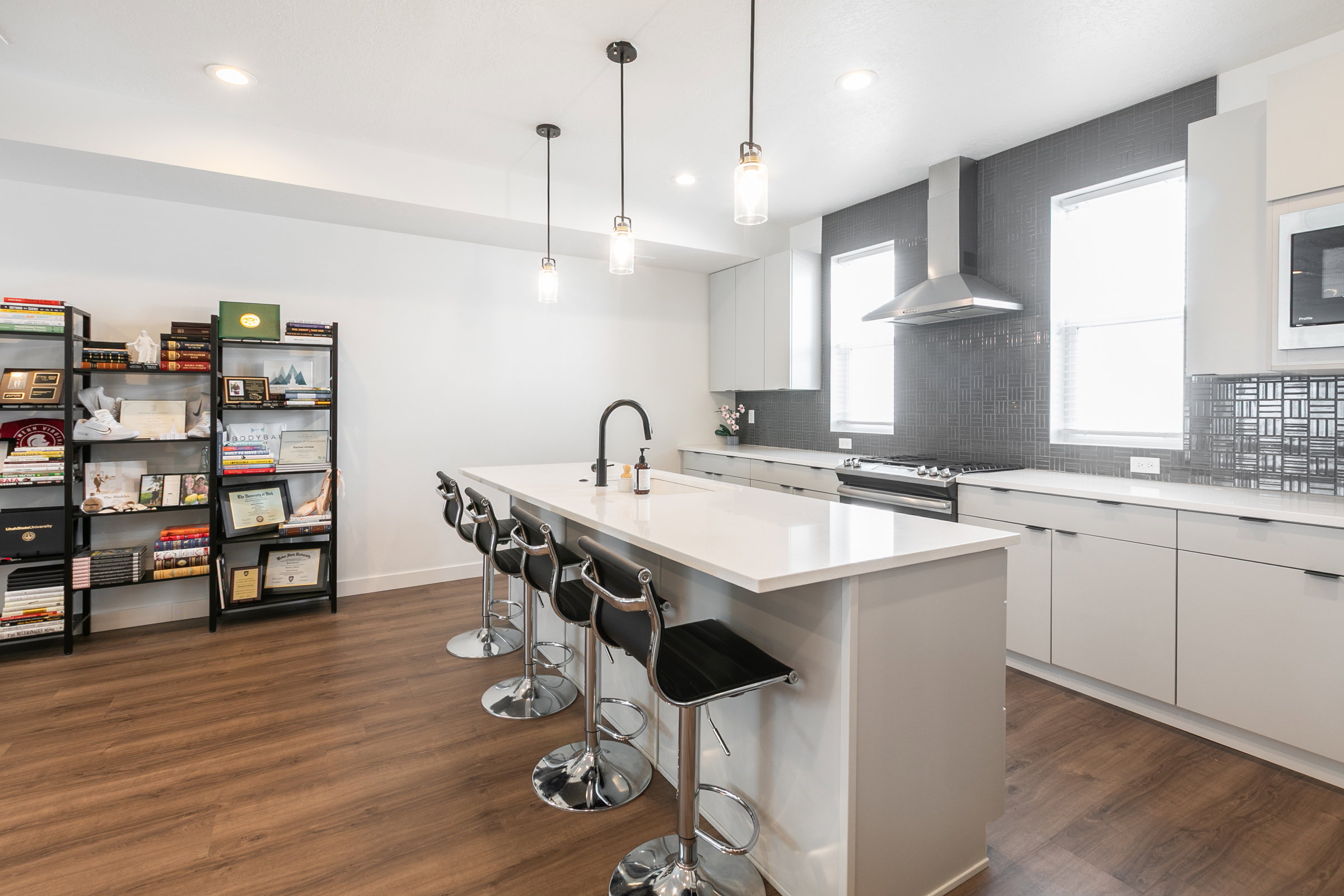 Modern kitchen featuring a large island with white countertop, sleek light cabinetry, and stainless steel appliances