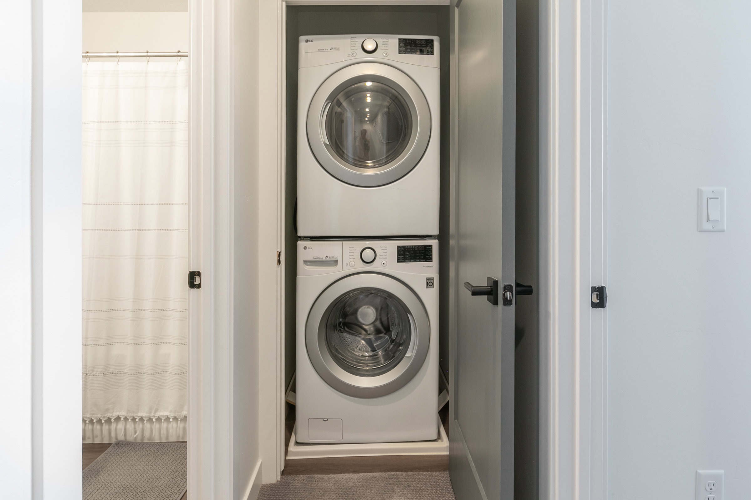 Dedicated laundry closet featuring a stacked washer and dryer unit