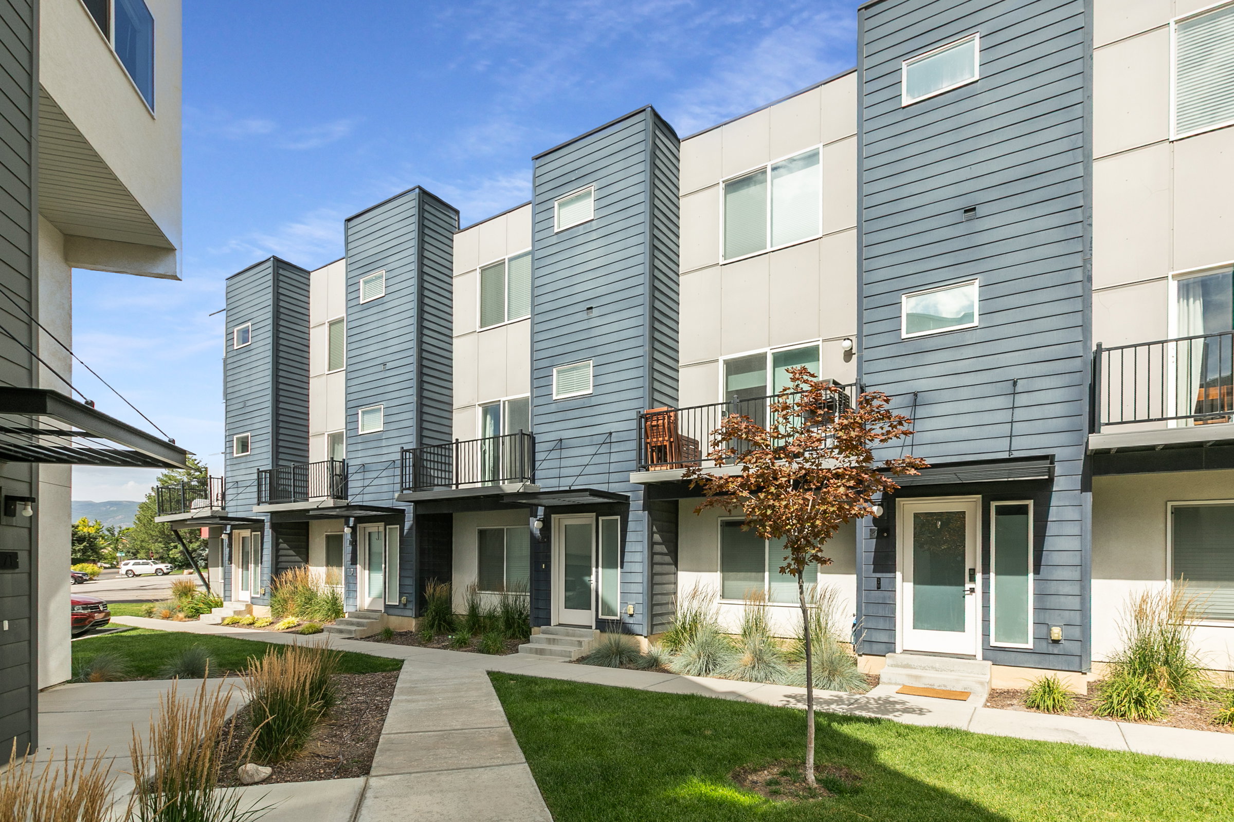 Modern townhome exteriors featuring horizontal siding in blue and gray tones