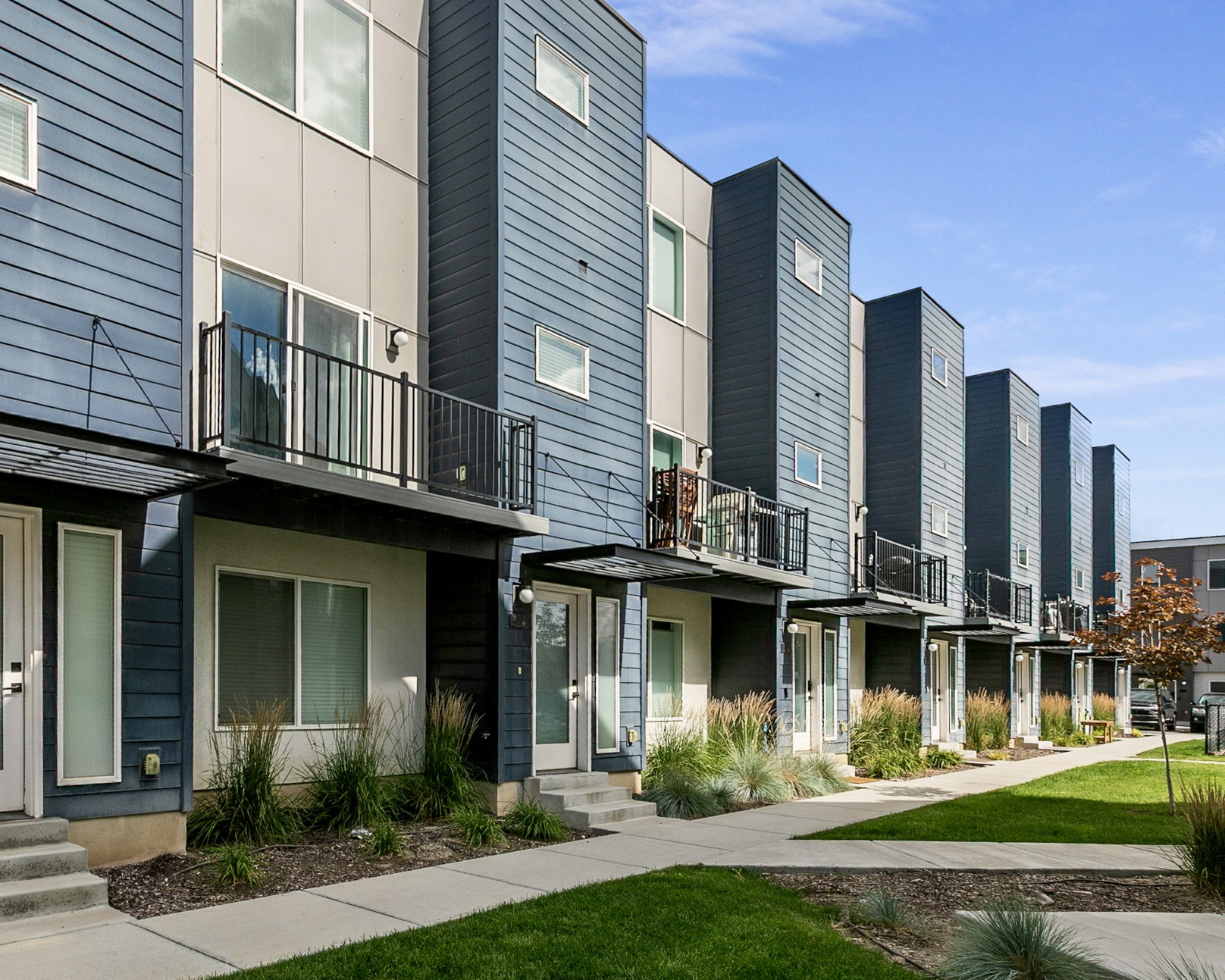 Contemporary multi-story townhome with a blue and gray facade