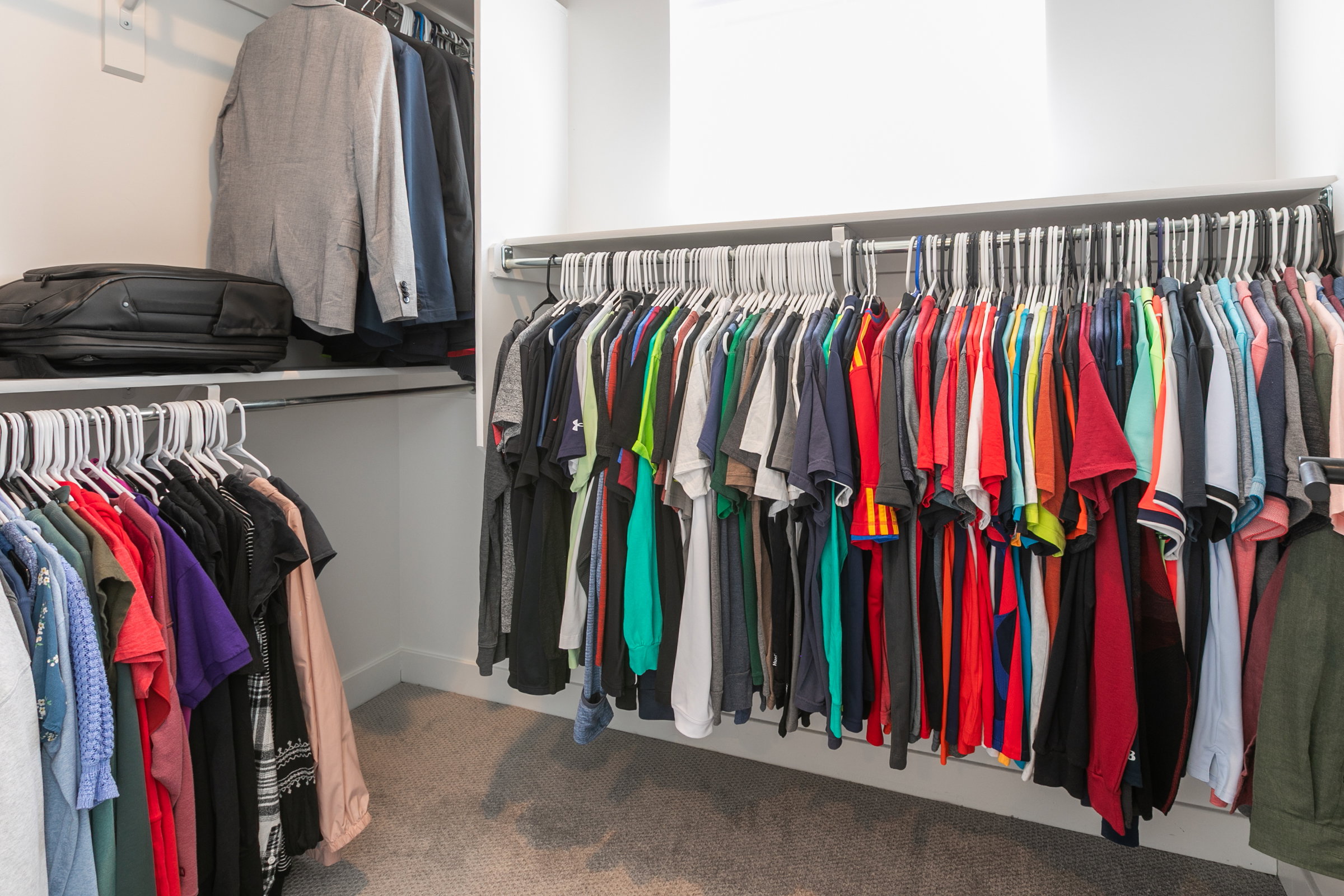 Integrated closet system featuring white shelving and hanging rods
