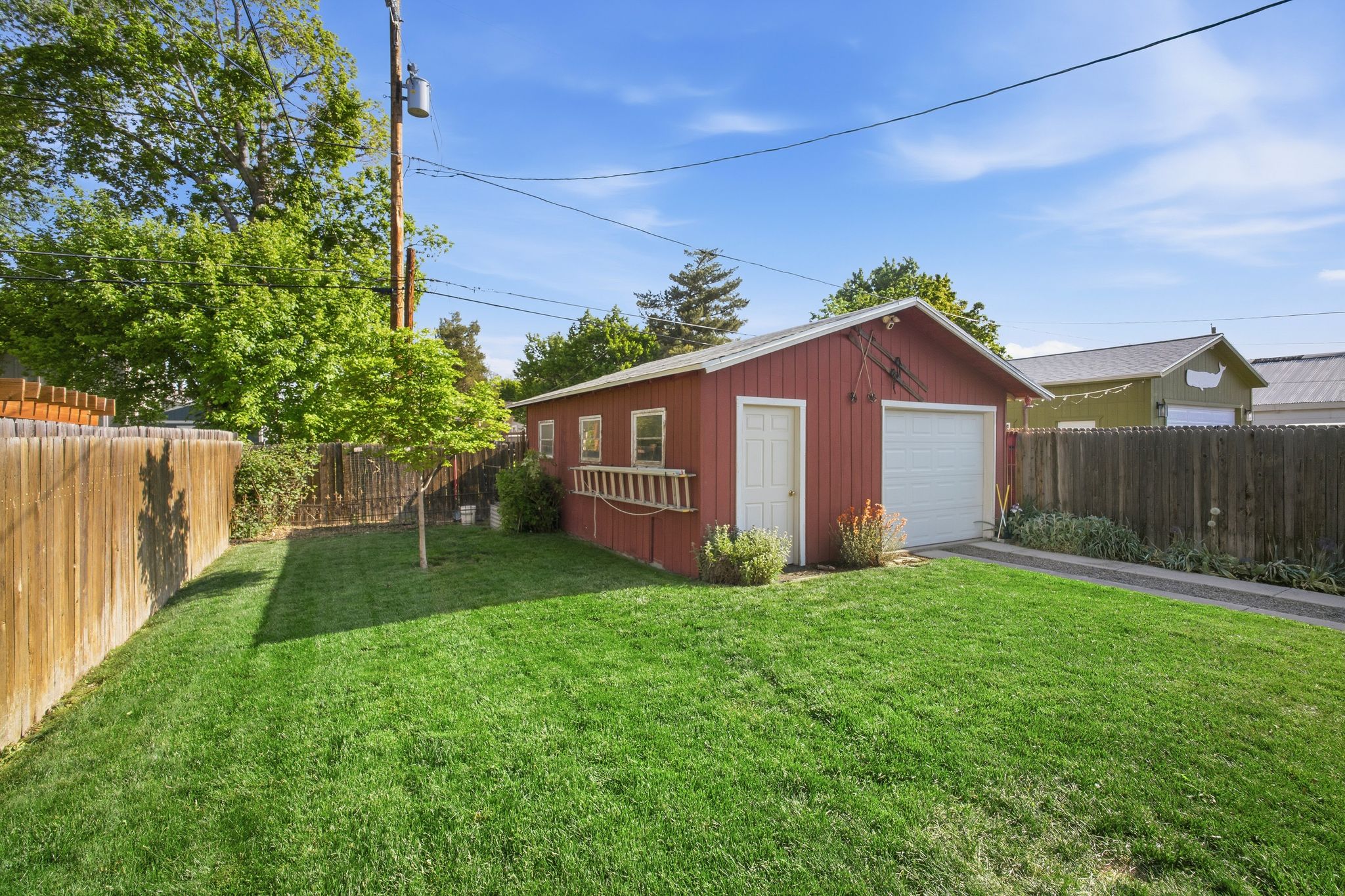 Detached red outbuilding featuring a single garage door and a separate entry door