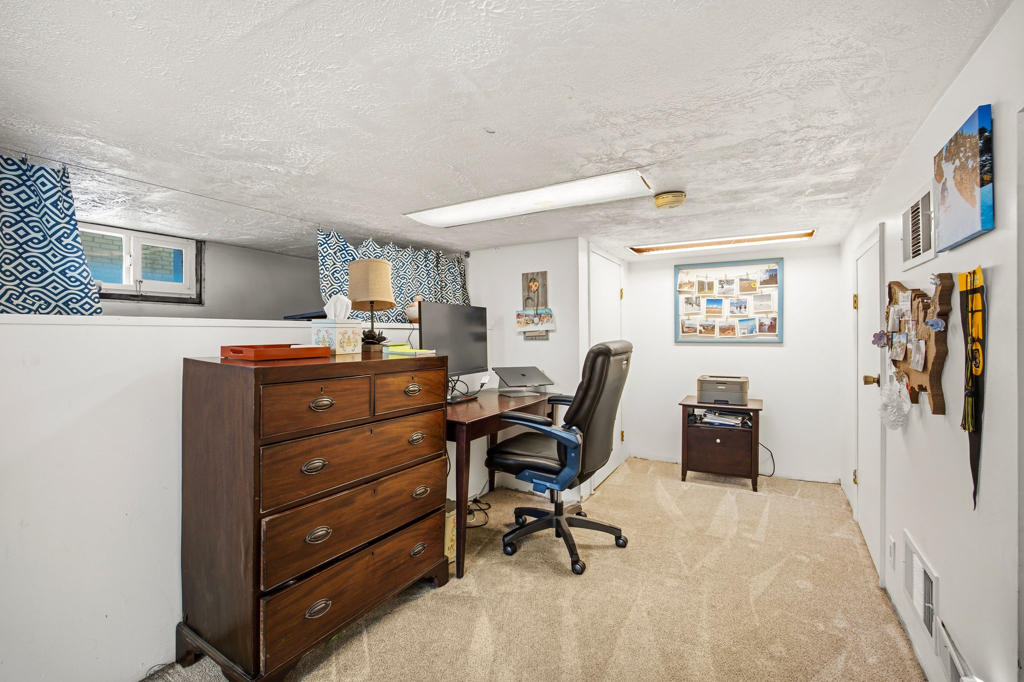 Carpeted interior space featuring white walls and a textured white ceiling