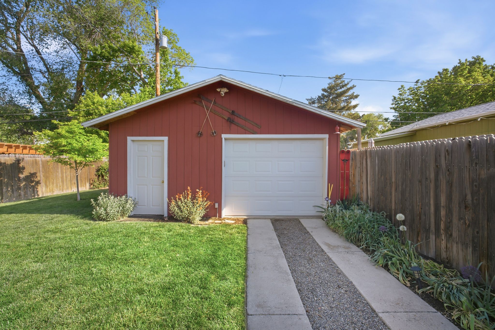 Detached red garage featuring a white overhead door and a white side entry door