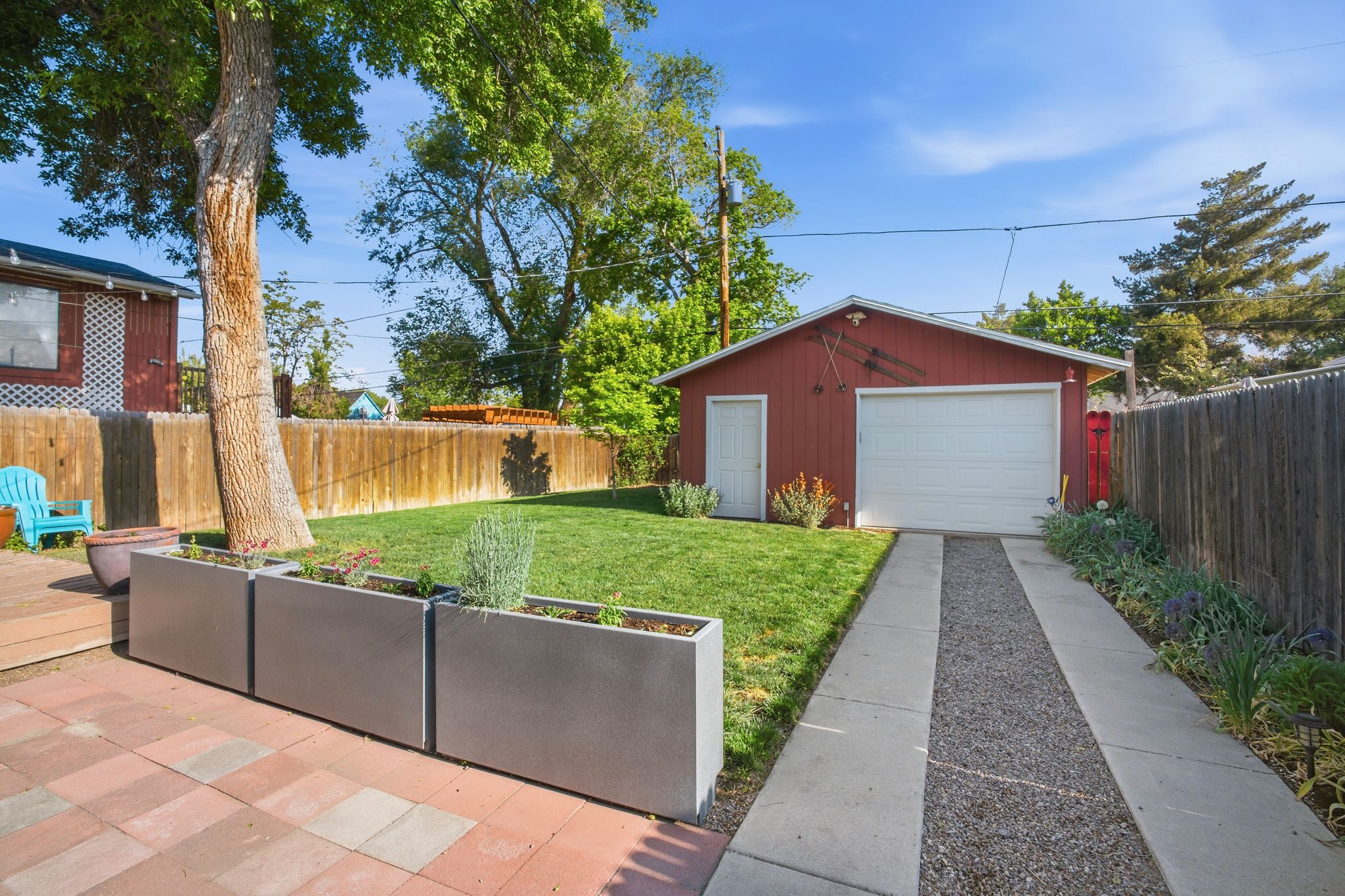 Detached red garage with a white garage door and side entry door