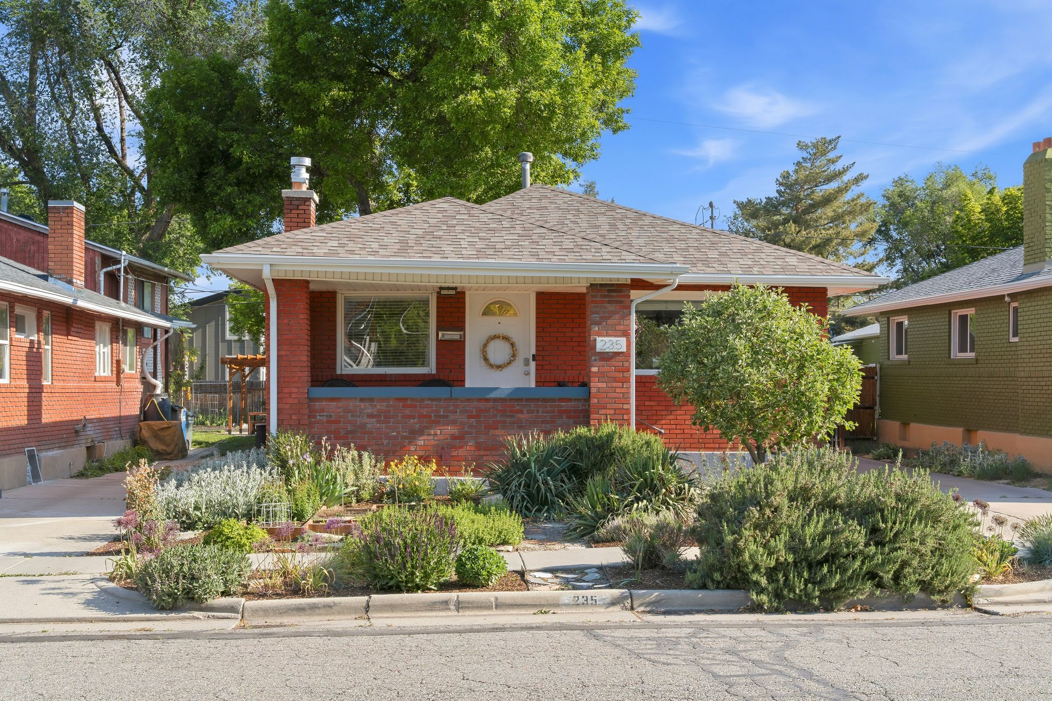 Red brick exterior with a pitched shingle roof, complemented by a raised foundation and a covered porch entry