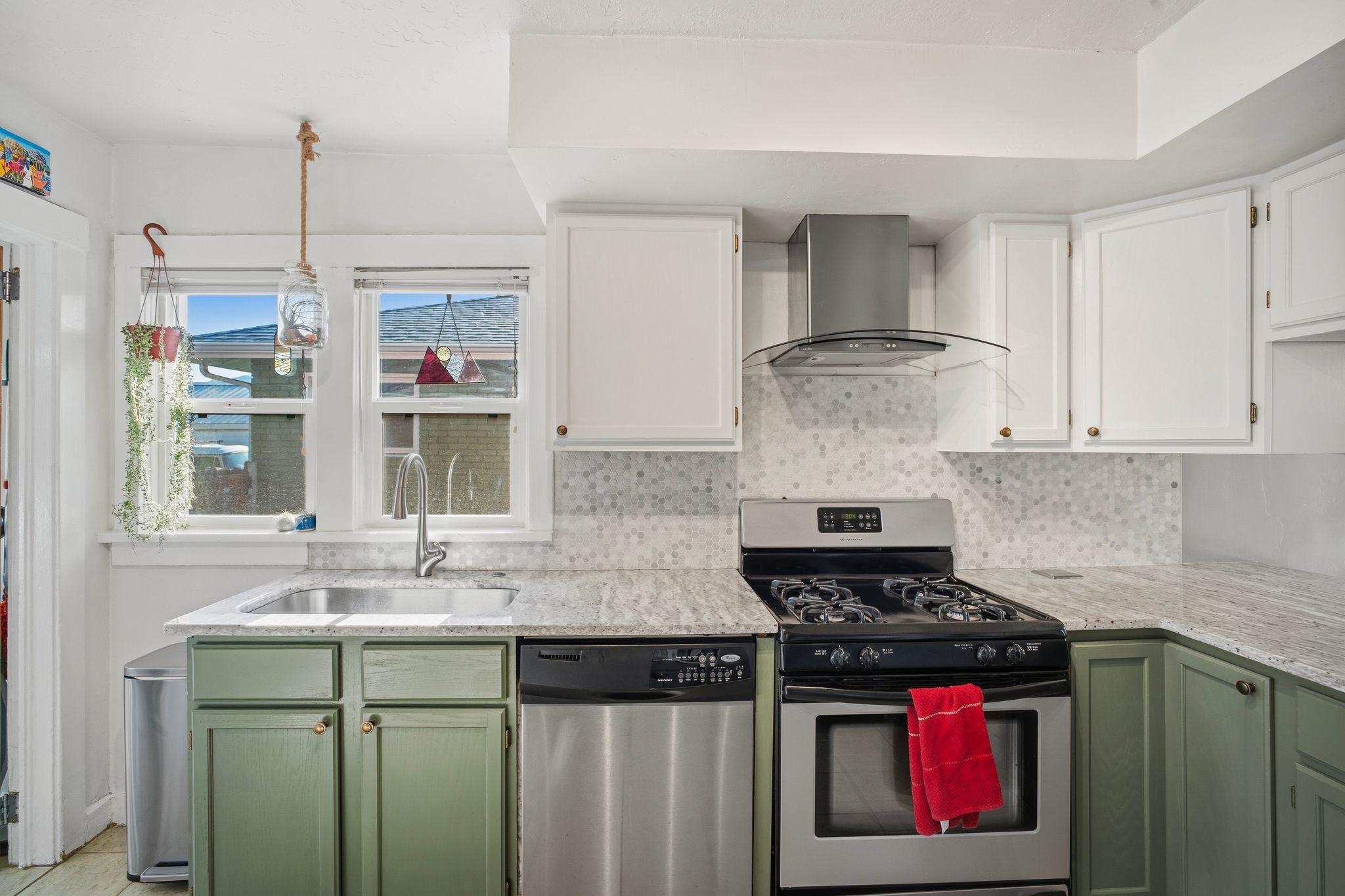 Kitchen featuring a stainless steel gas range, coordinating stainless steel dishwasher, and a contemporary range hood