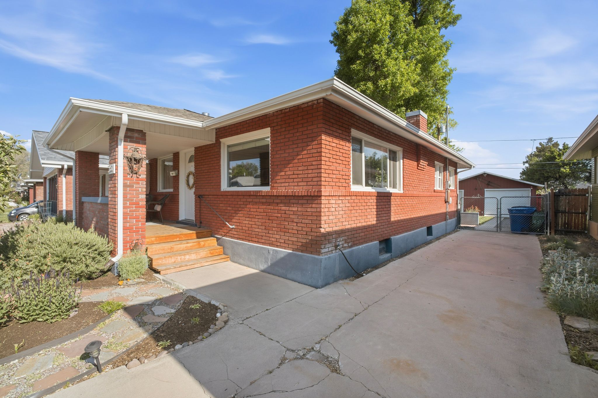 Brick exterior with white trim windows and a covered front porch featuring wood steps