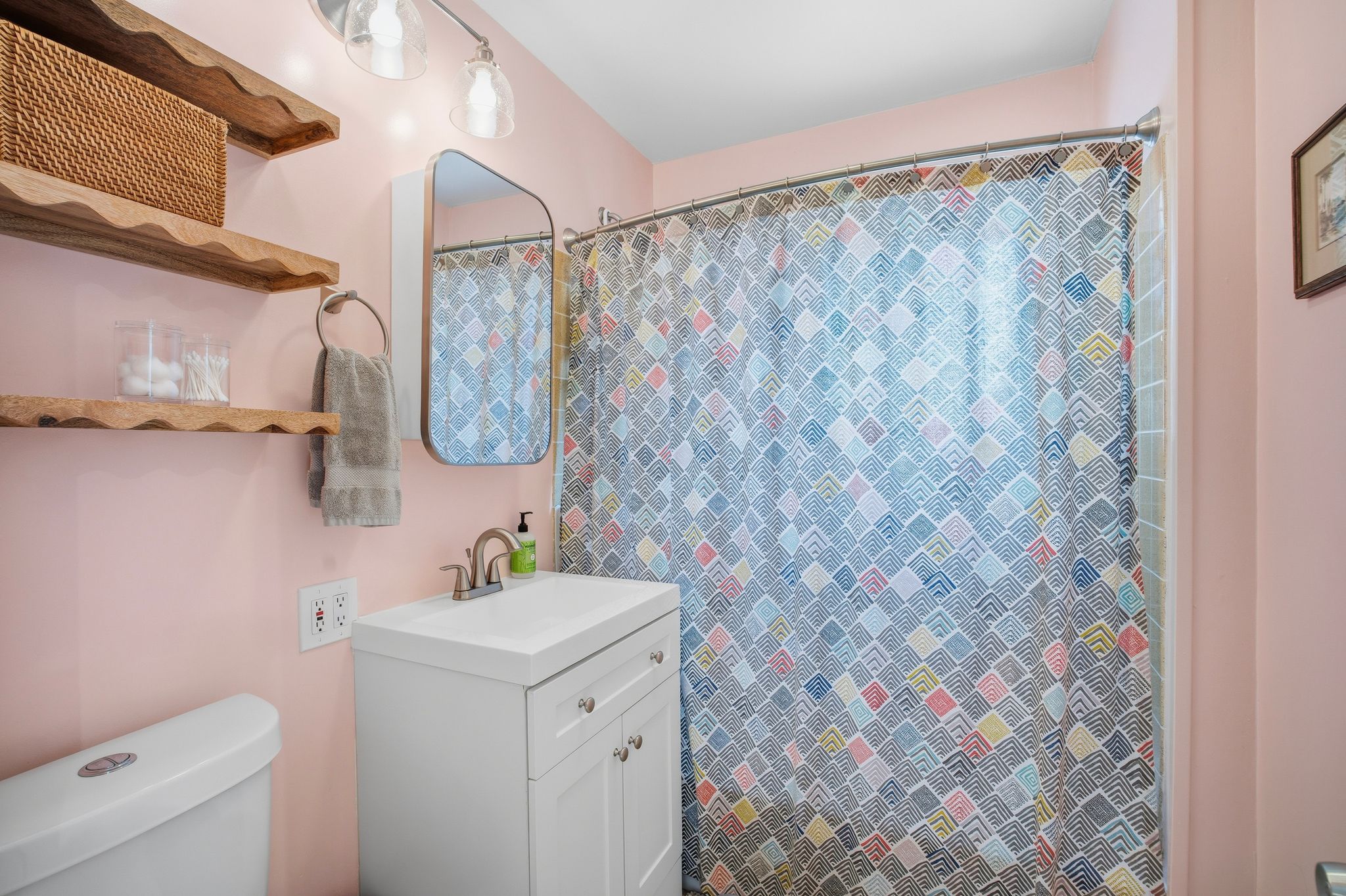Bathroom featuring a white vanity with integrated sink, brushed nickel faucet, and a wall-mounted medicine cabinet