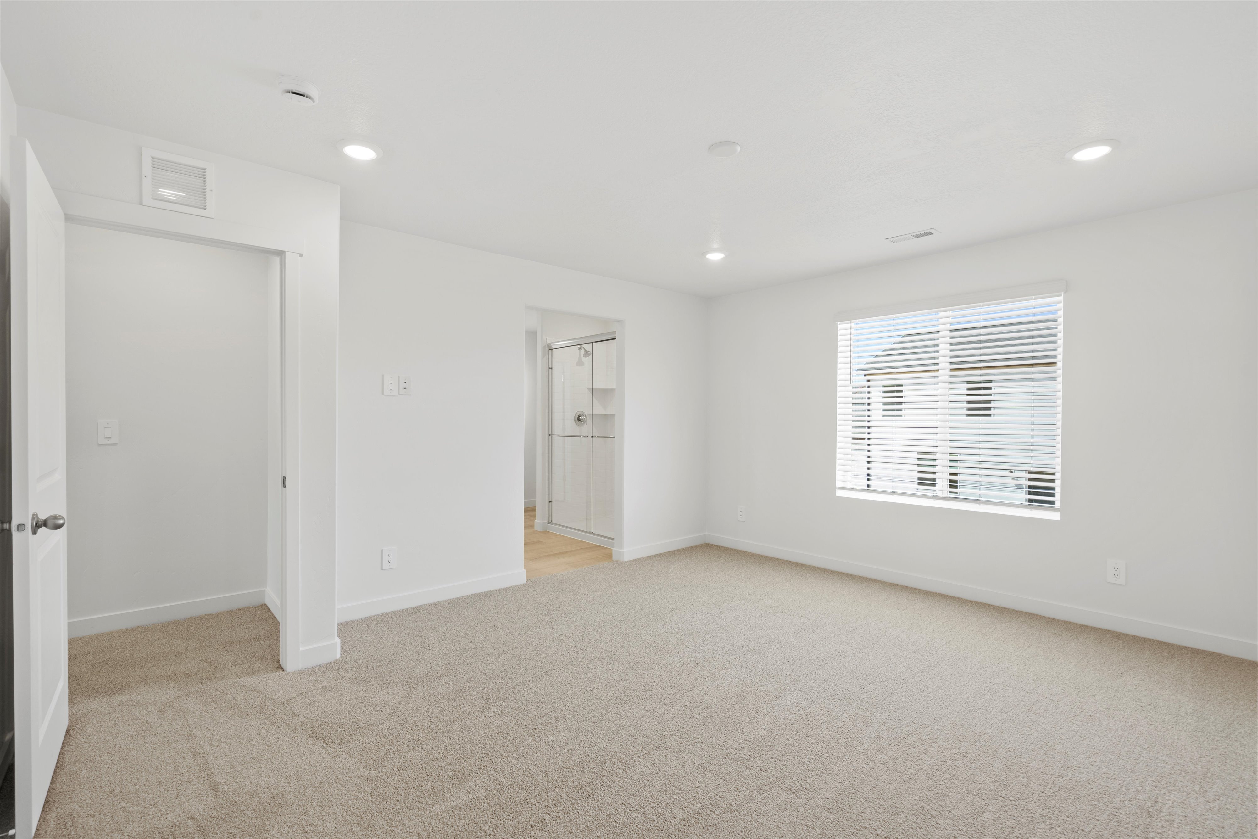 Spacious room with plush carpeting and recessed lighting