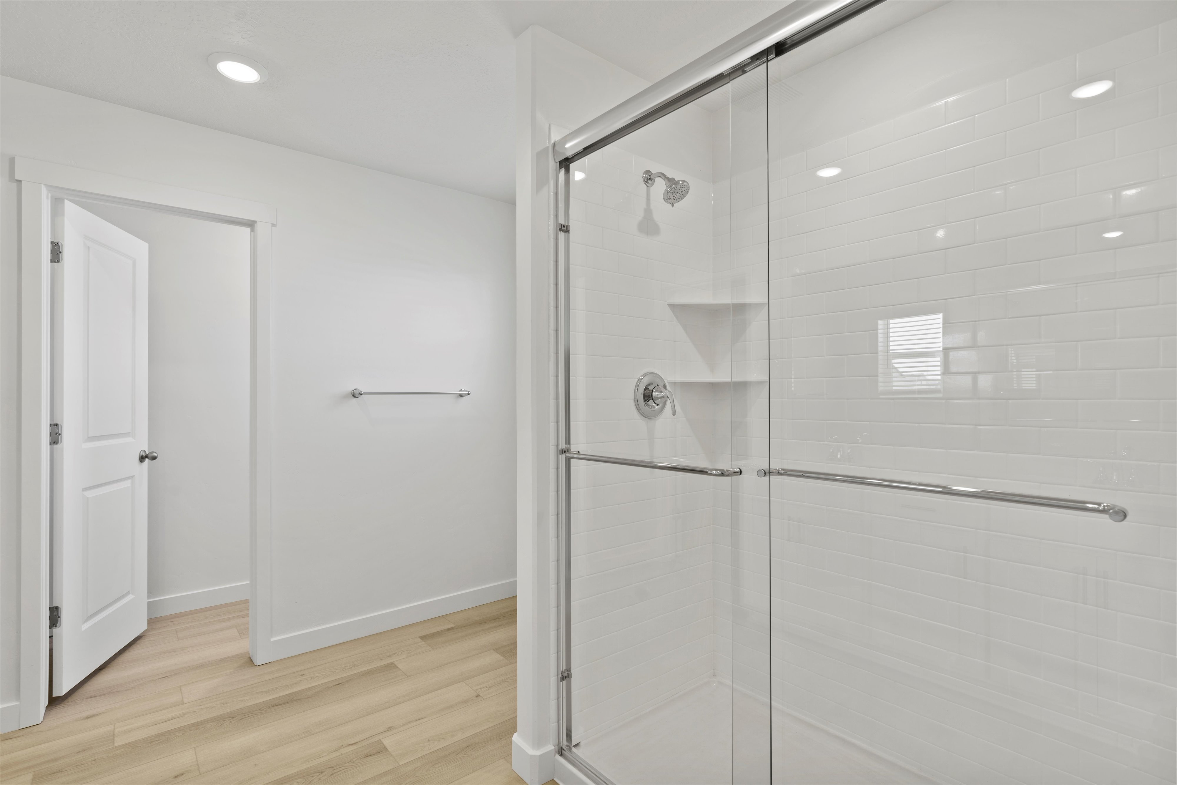 Shower enclosure featuring clear glass sliding doors and polished chrome hardware