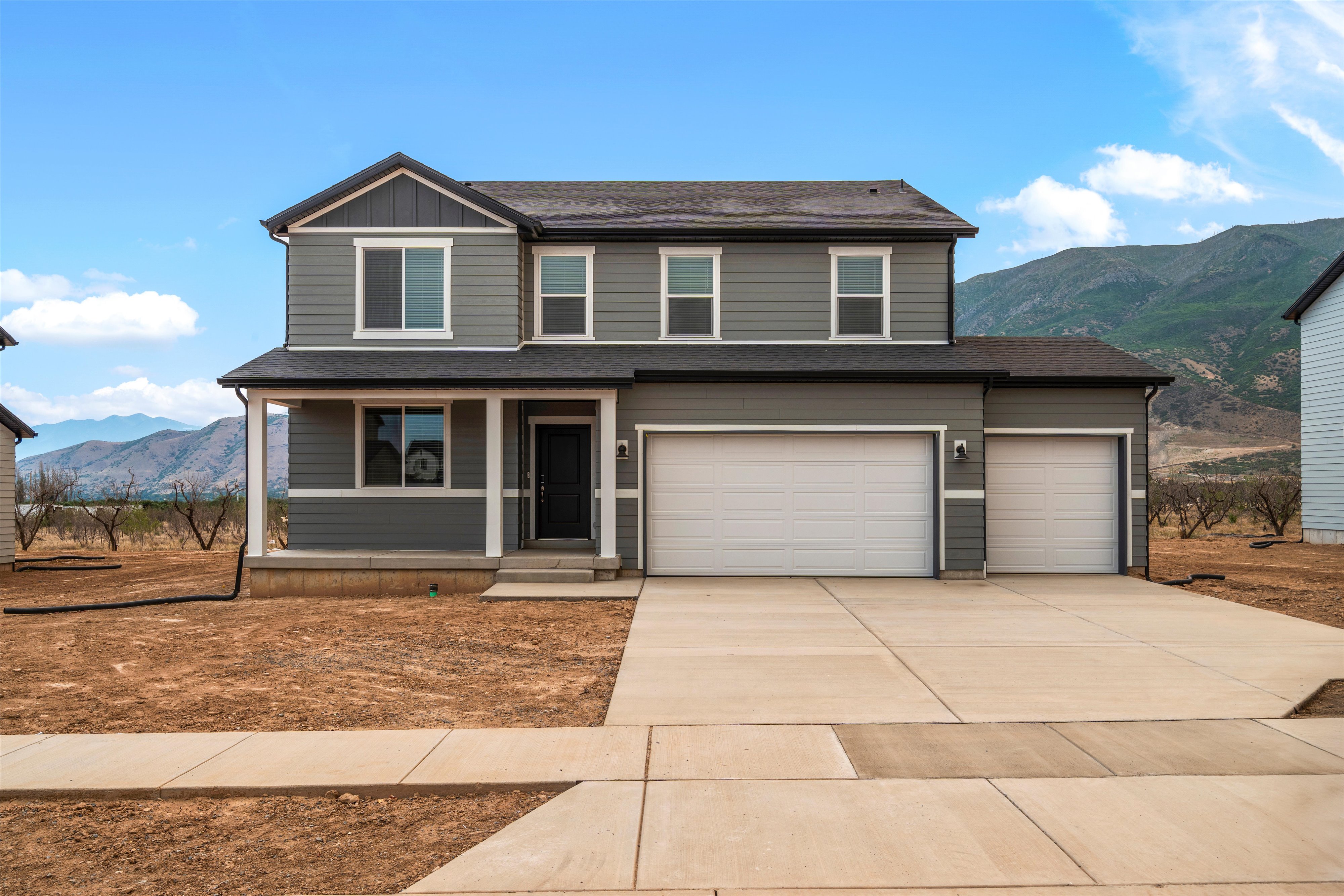 Two-story residence featuring grey siding with white trim accents and a dark roof
