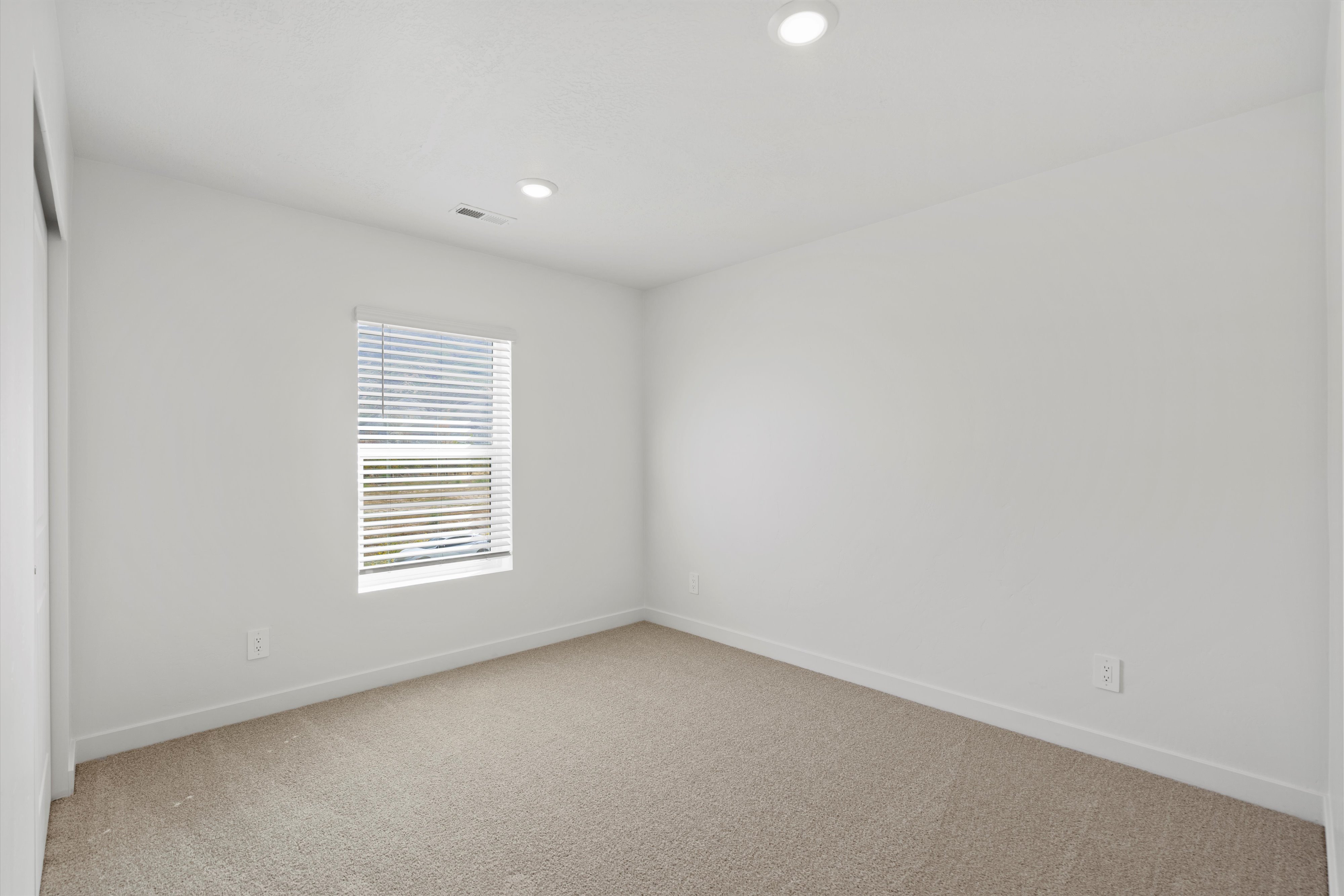 Neutral-toned carpeting paired with white baseboards and walls