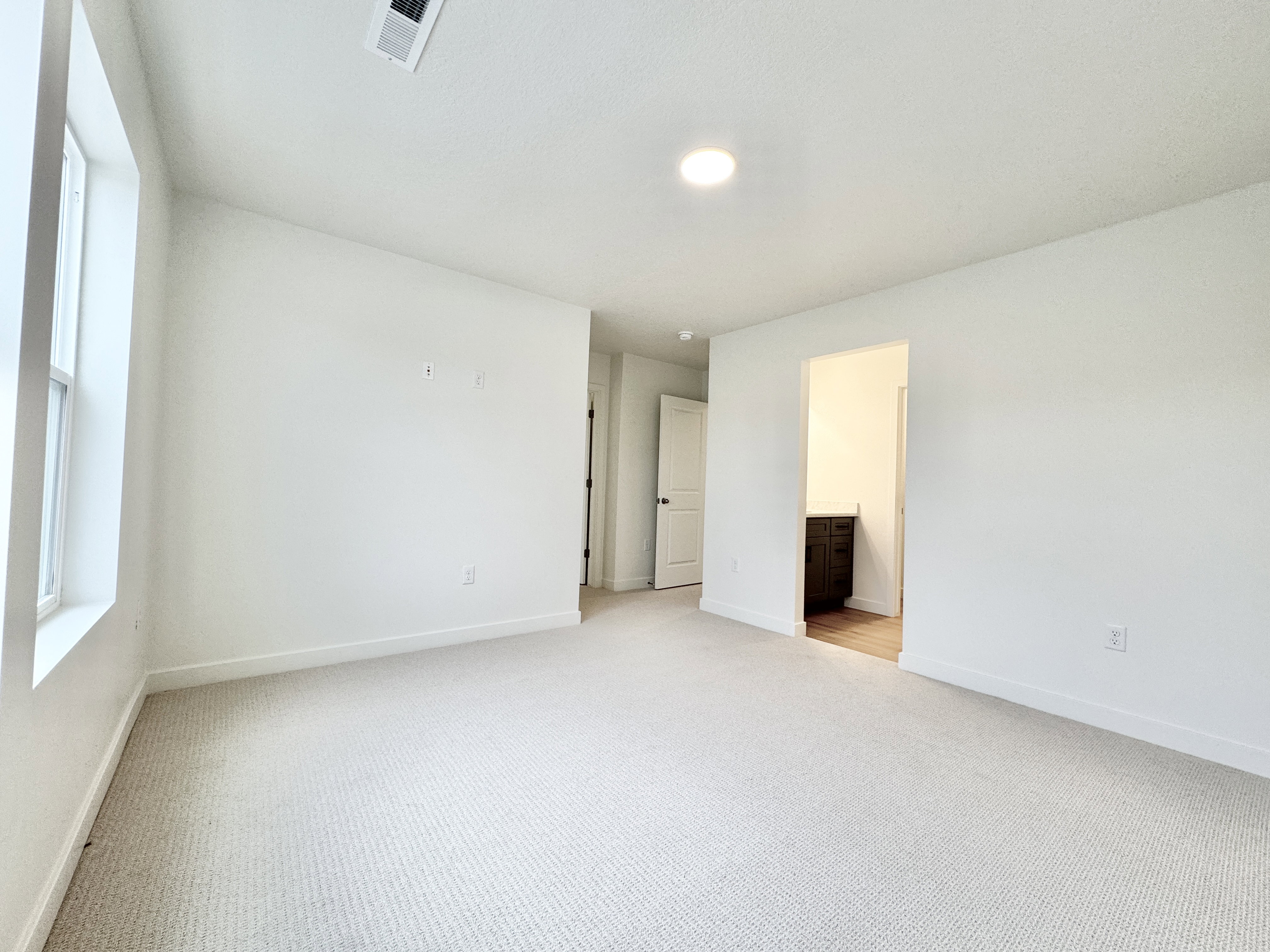 Carpeted interior space featuring white walls and a window