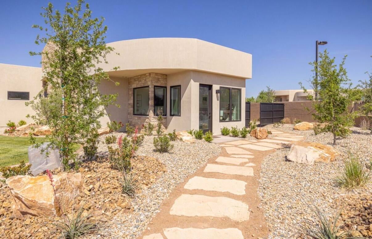 Contemporary stucco exterior with stone accents and black-framed windows