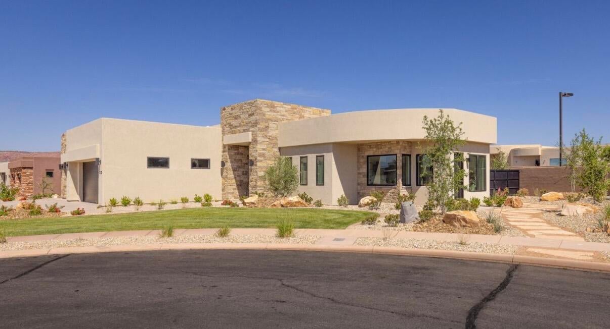 Modern desert architecture featuring a light stucco exterior with stone accents
