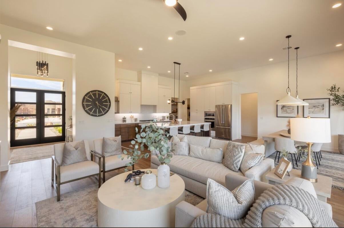 Open-concept living space featuring wood-finish flooring, recessed lighting, and a modern kitchen with a large island