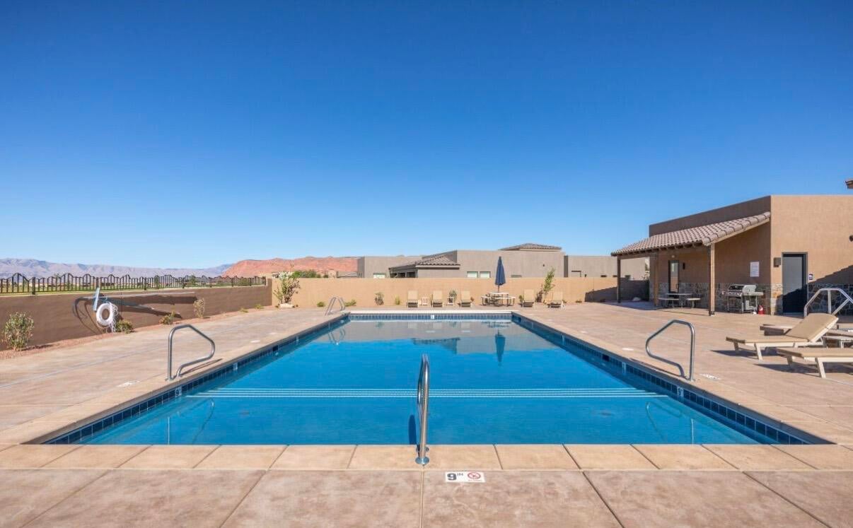 Rectangular swimming pool with integrated steps, surrounded by extensive concrete decking