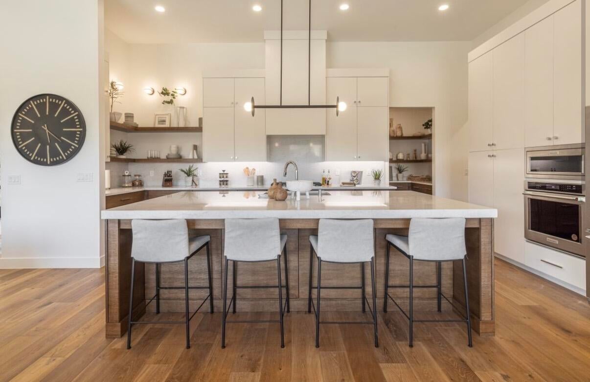 Expansive kitchen island with seating for four, complemented by wood-finish flooring