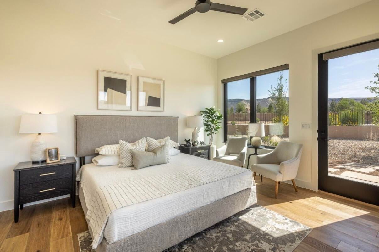 Spacious room featuring wood-finish flooring, large windows, and a glass-paneled door