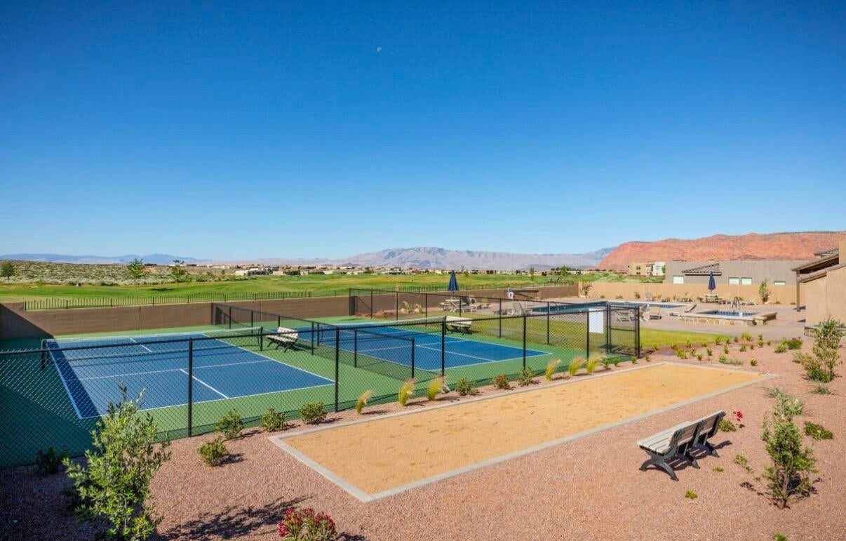 Recreational area featuring two fenced sport courts, a sand bocce ball court, and a resort-style pool area