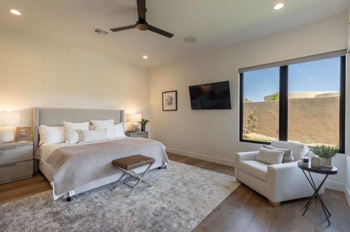 Spacious bedroom featuring wood-finish flooring, recessed lighting, and a contemporary ceiling fan